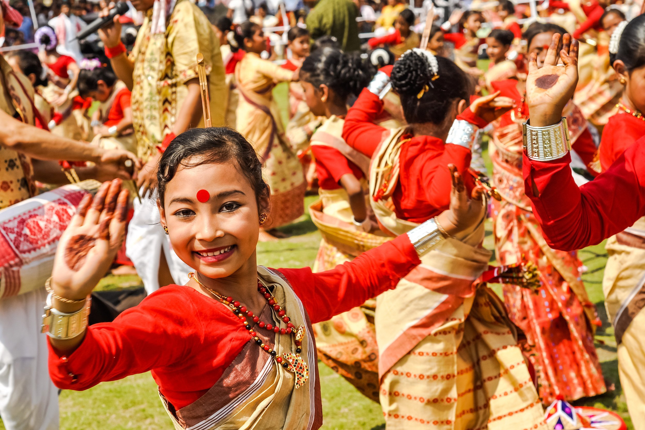 dancing girl smiles during performance at traditional Bihu festival in Guwahati, Assam
