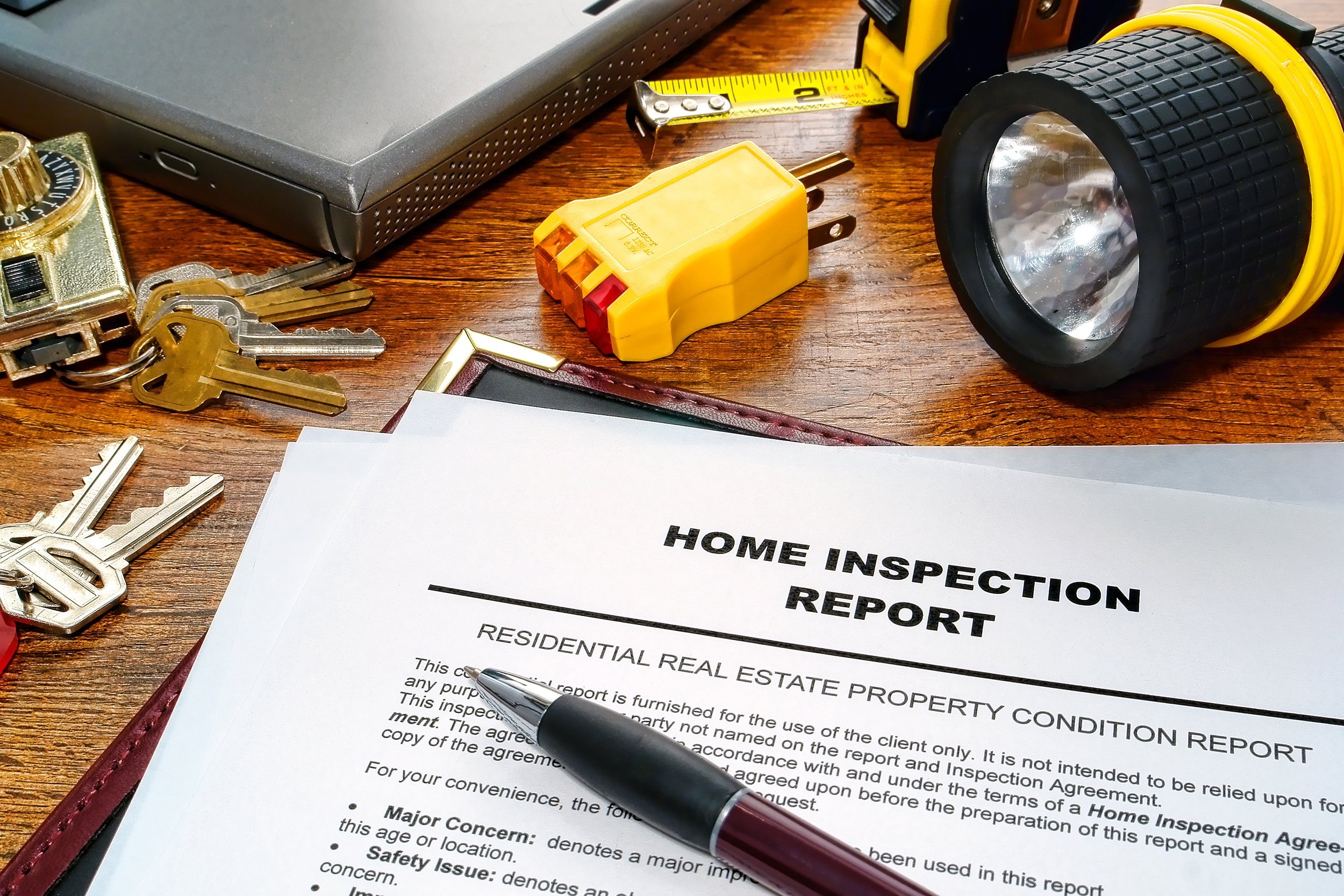 real estate home inspection report with testing tools and house keys