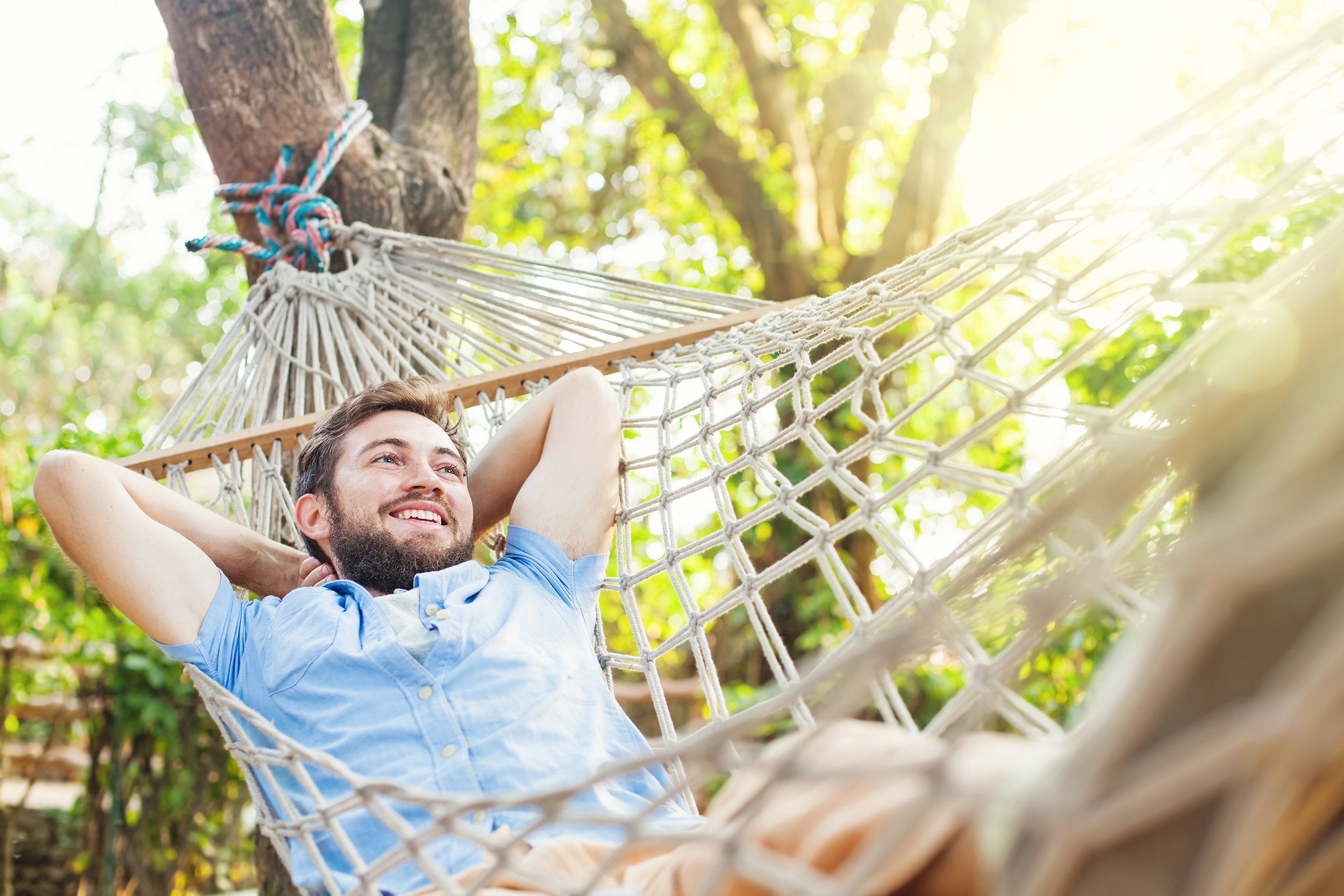 man swinging in a hammock in a pleasant laziness of a weekend morning