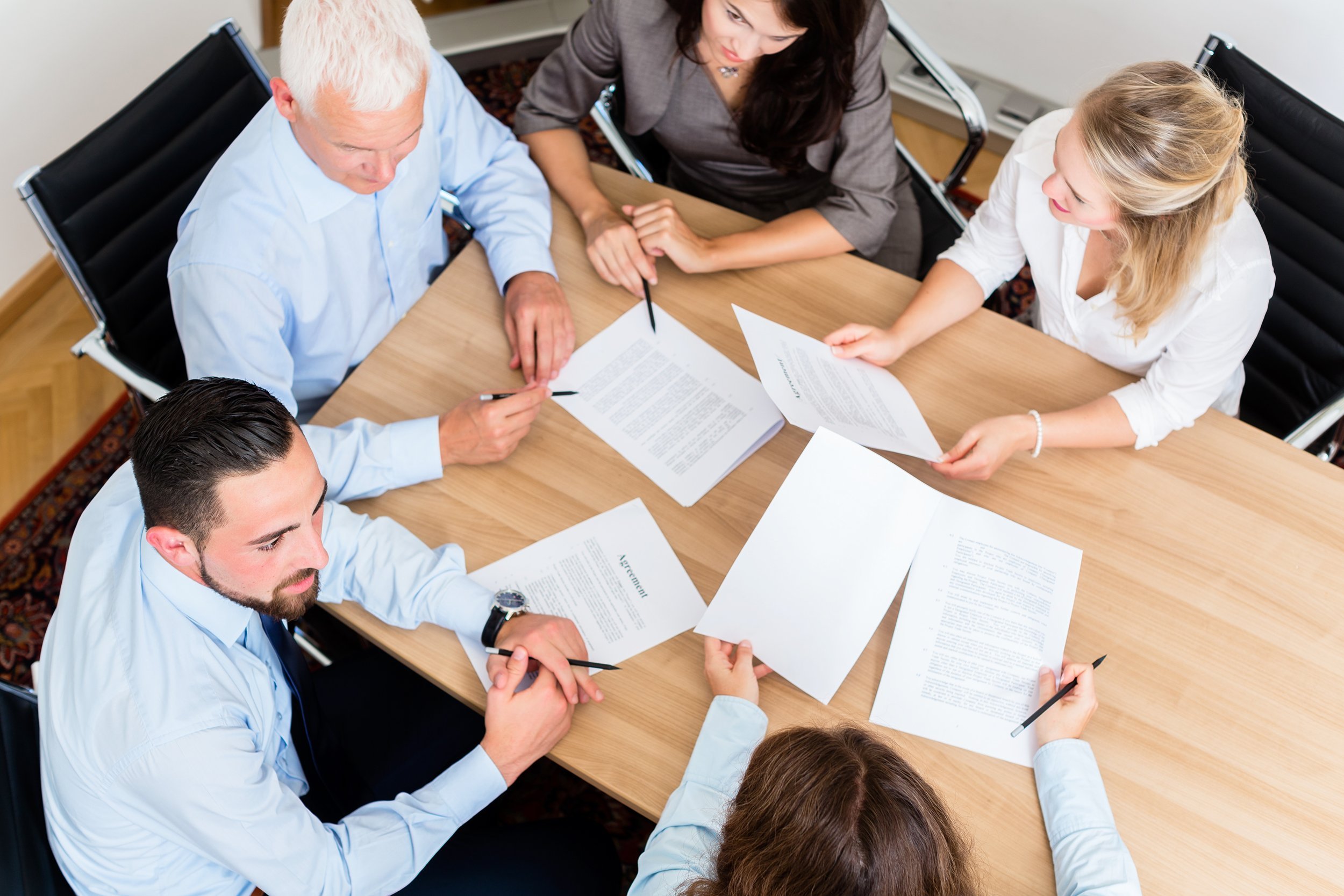 lawyers having team meeting in law firm reading documents and negotiating agreements