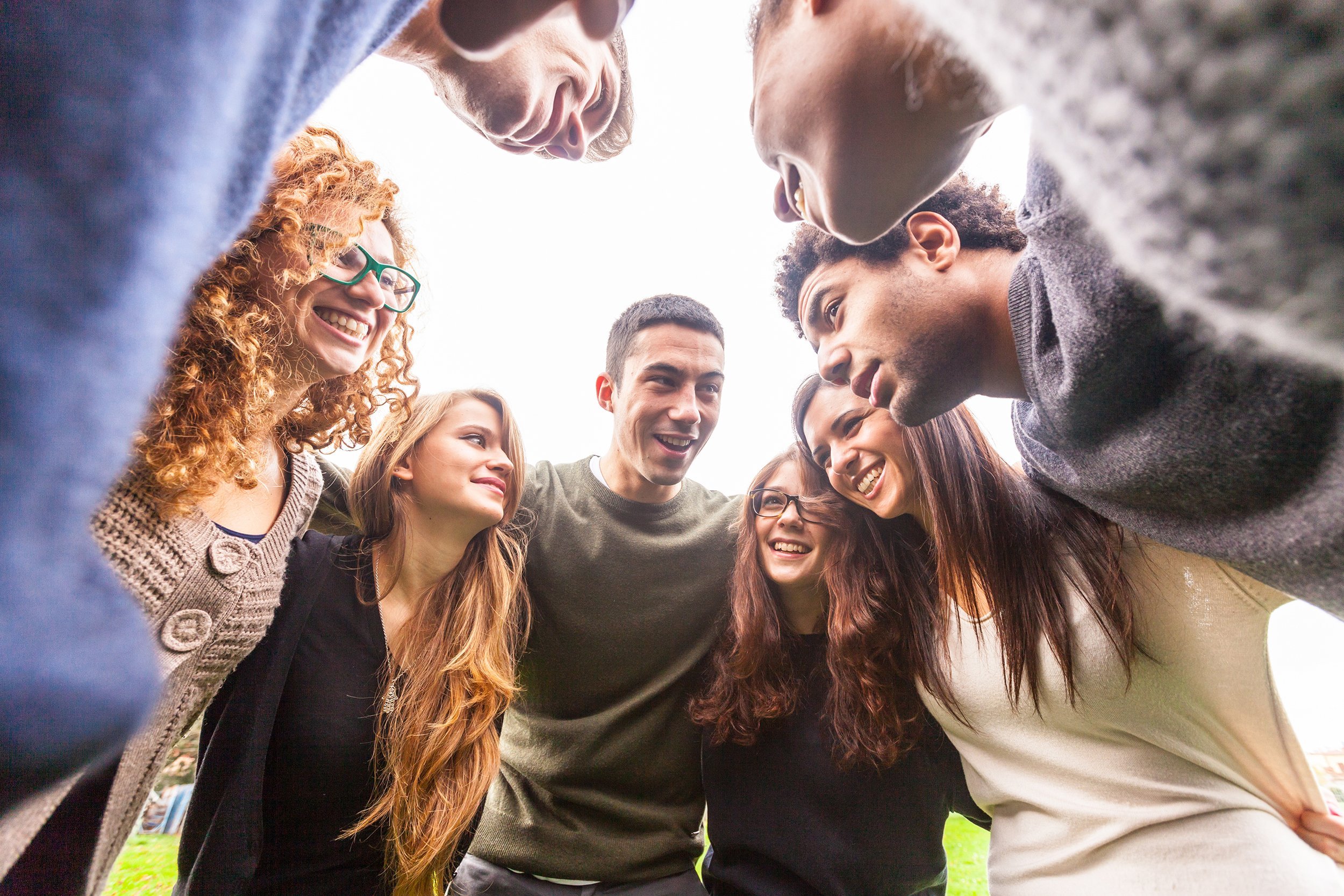 multiracial group of friends embraced in a circle