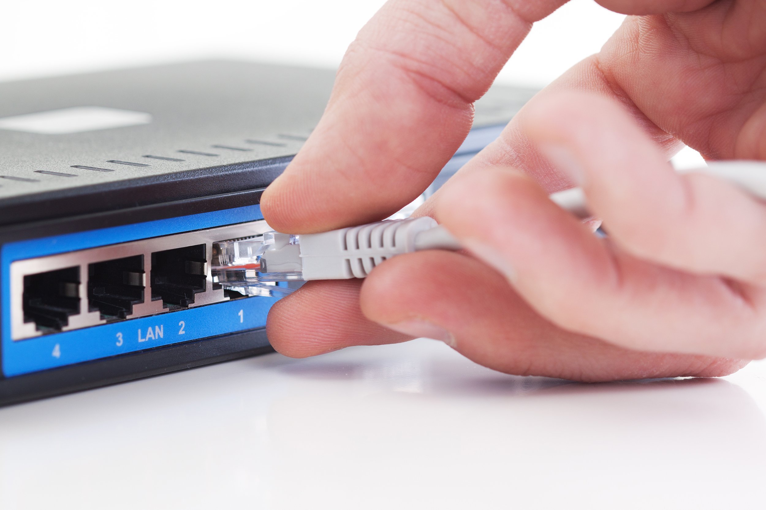 hand plugging network plug into router