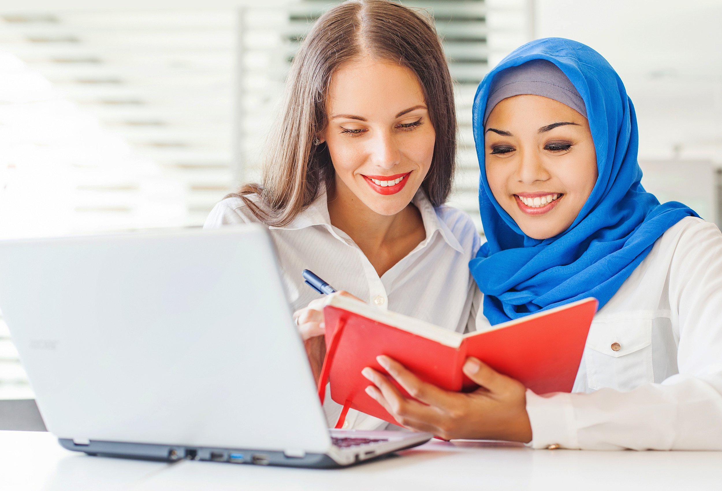 native speaker teaching a muslim asian girl in a light classroom in college