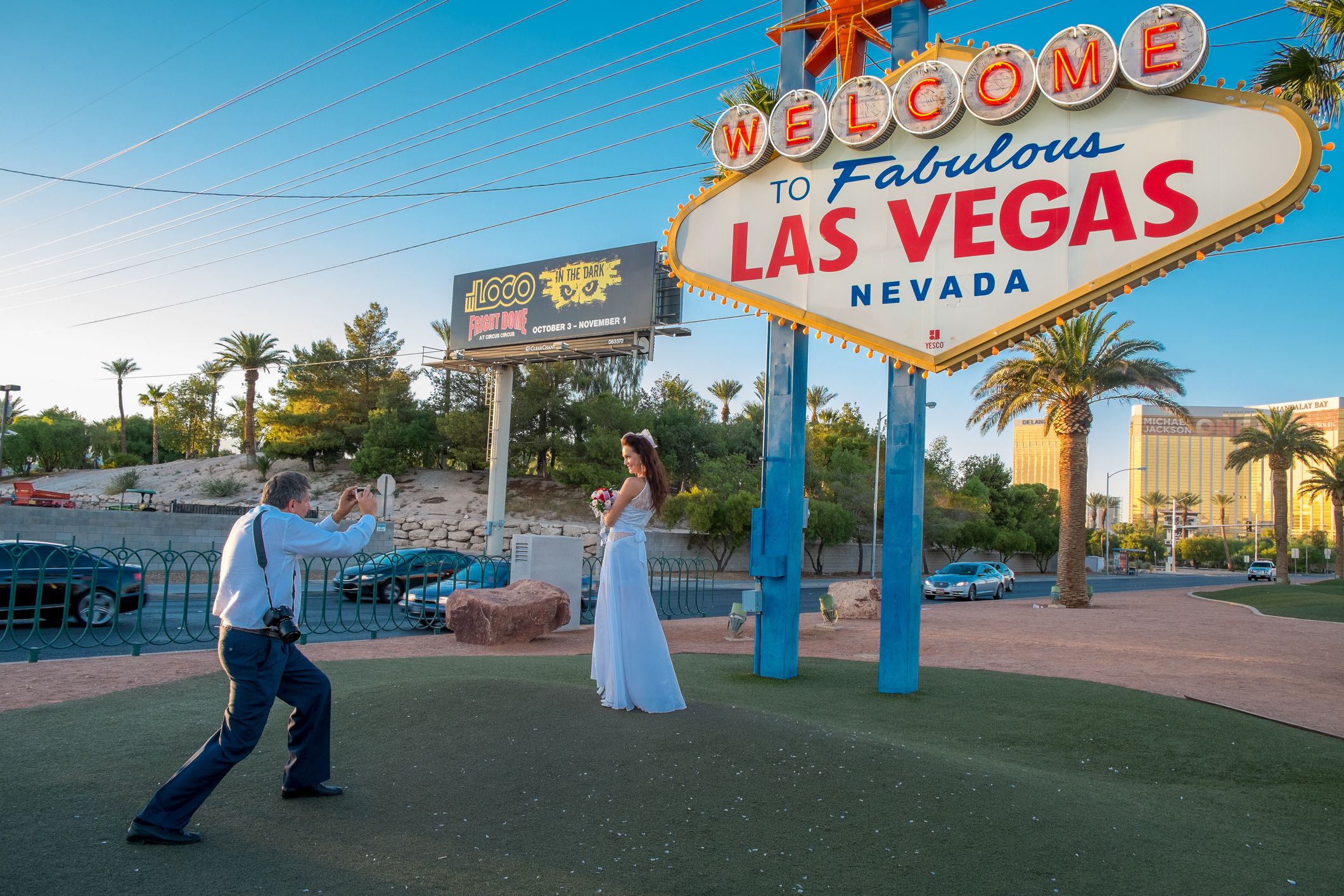 Las Vegas, USA – October 7, 2014: A bride being photographed by the groom at the Welcome to Fabulous Las Vegas sign on the southern part of Las Vegas Boulevard. This iconic sign attracts crowds of tourists having their photo taken here.