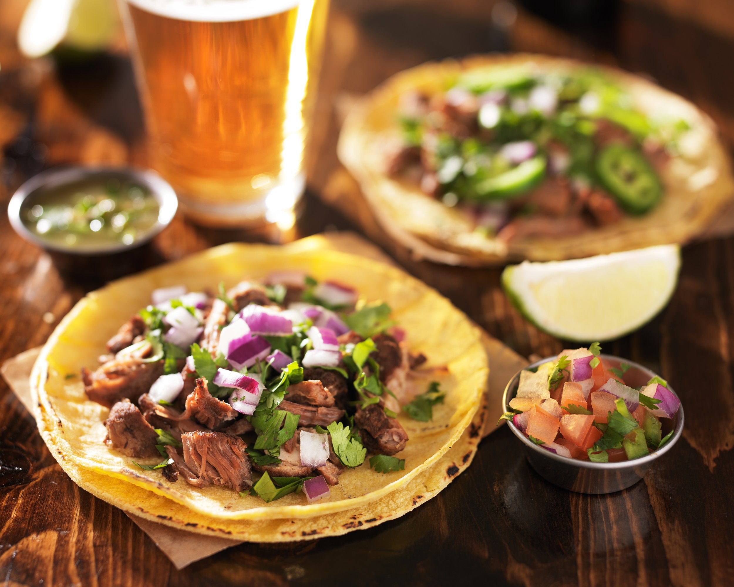 mexican tacos with beer on wooden table