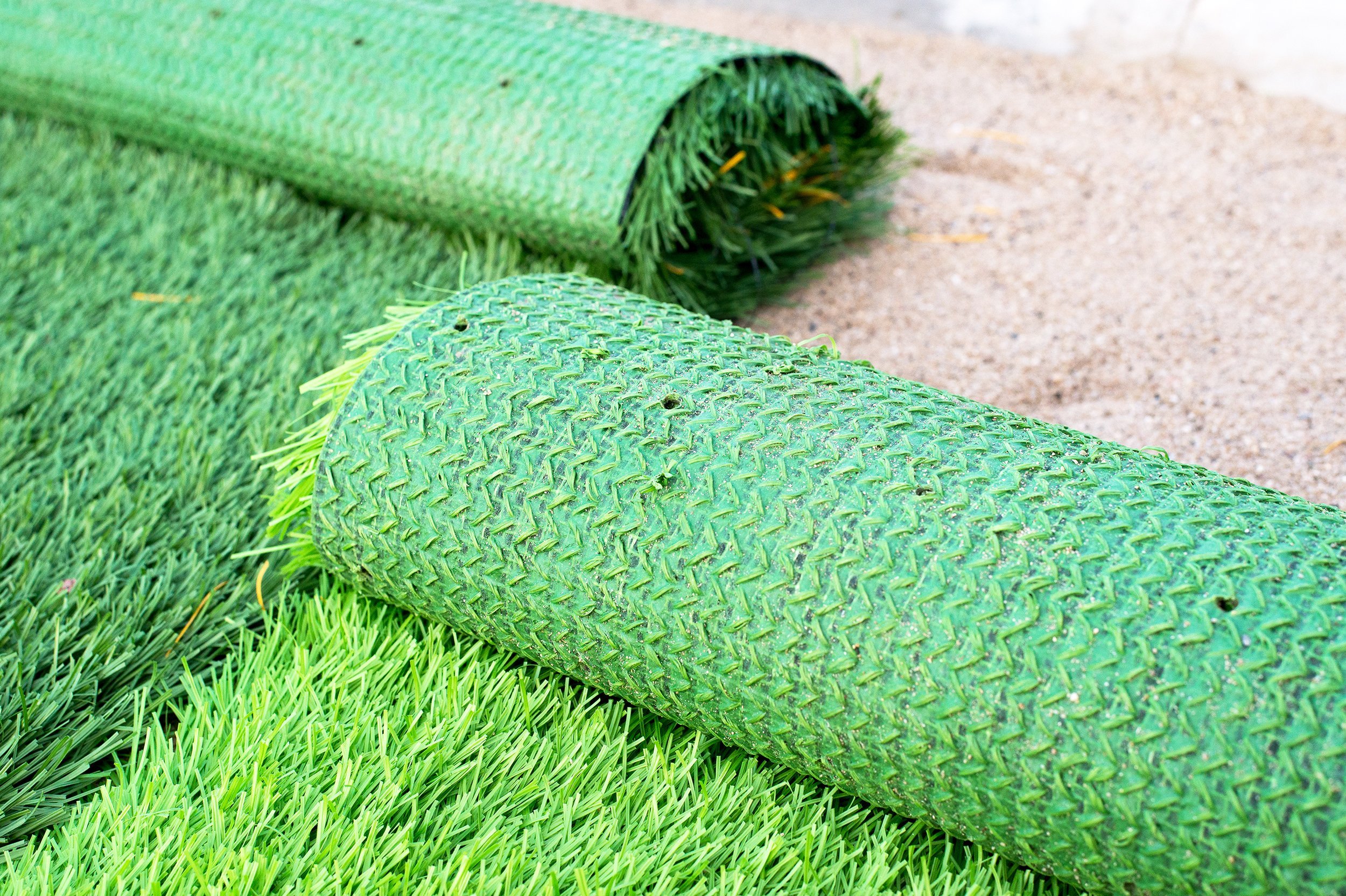 two kinds of artificial green grass on sand