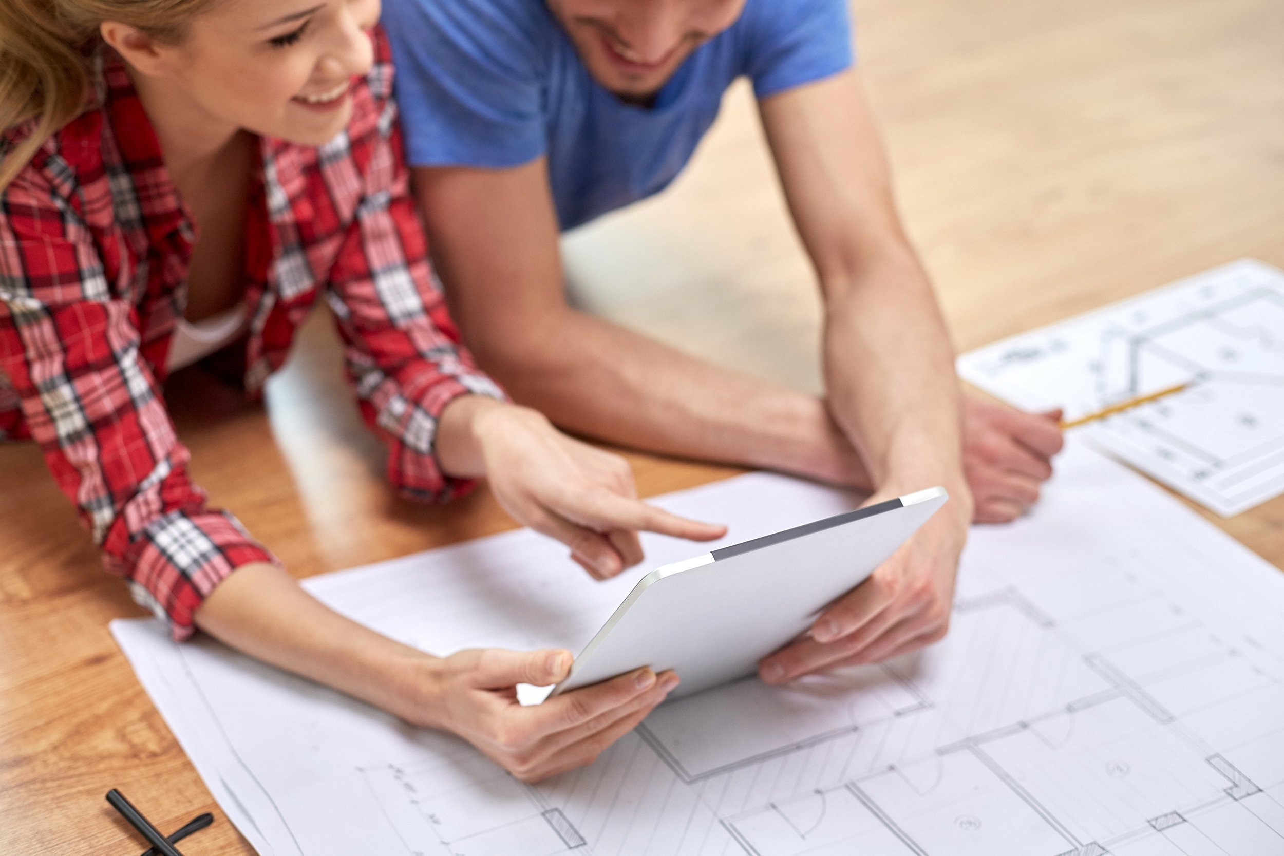 couple with tablet pc and blueprint at home