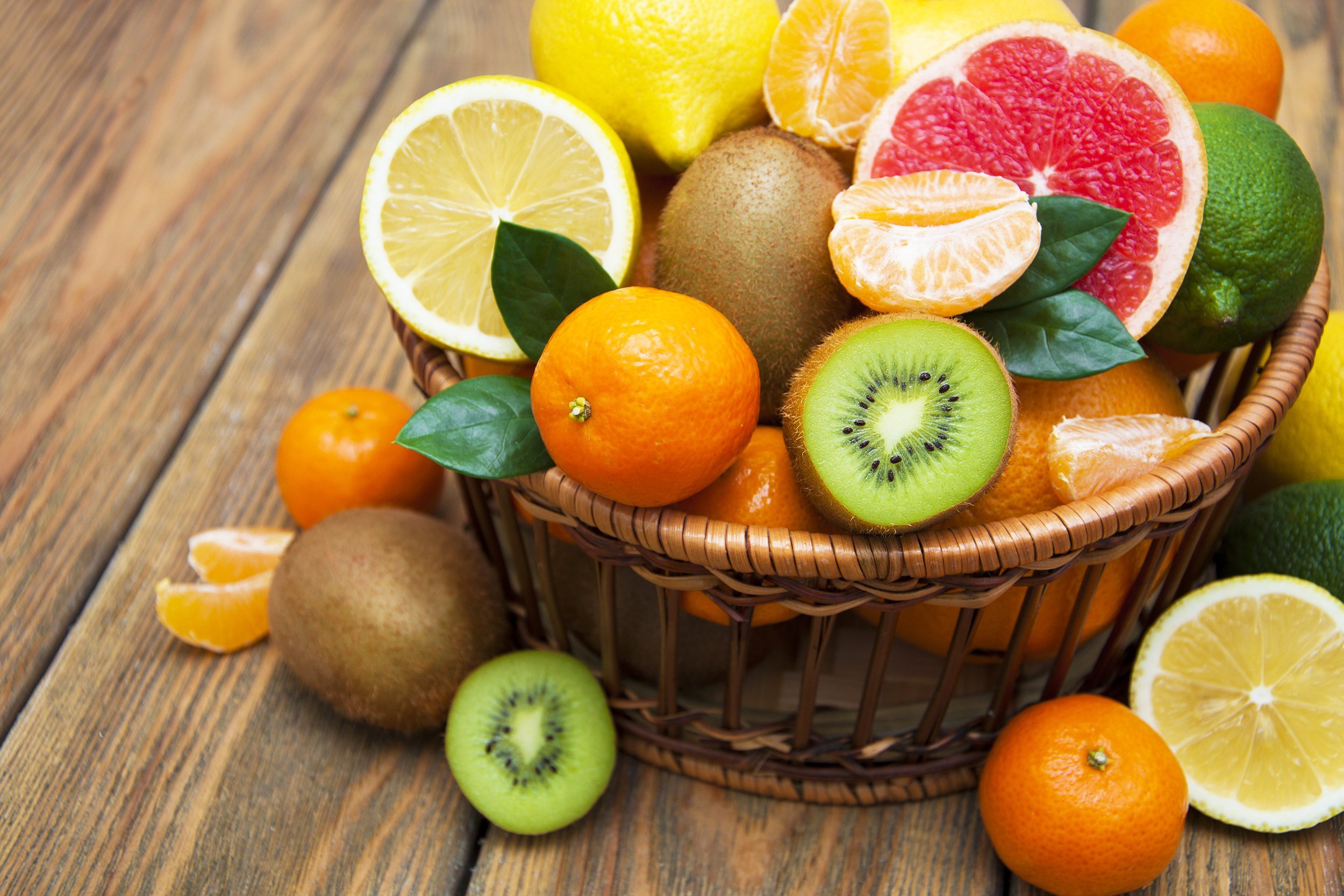 citrus fruits in a basket on a wooden background