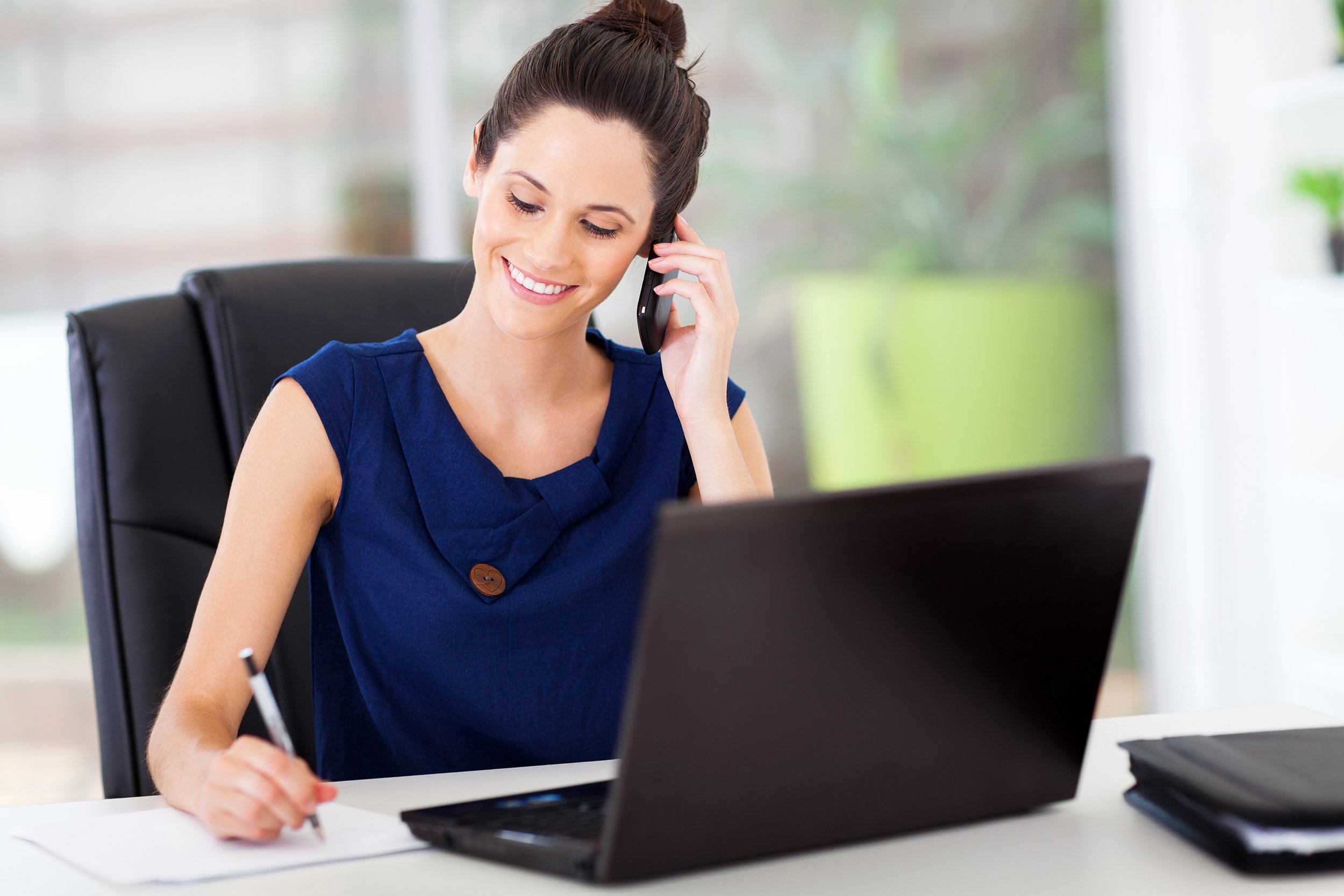 young office worker talking on cell phone in office