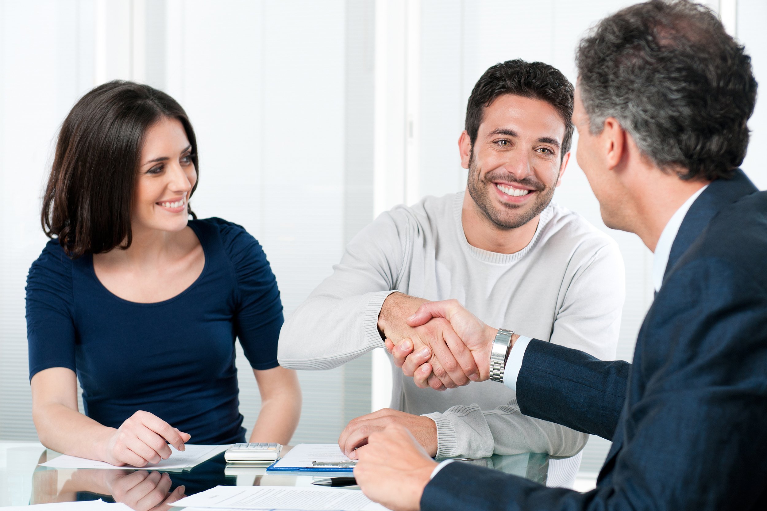 happy couple seal a deal with their personal financial advisor
