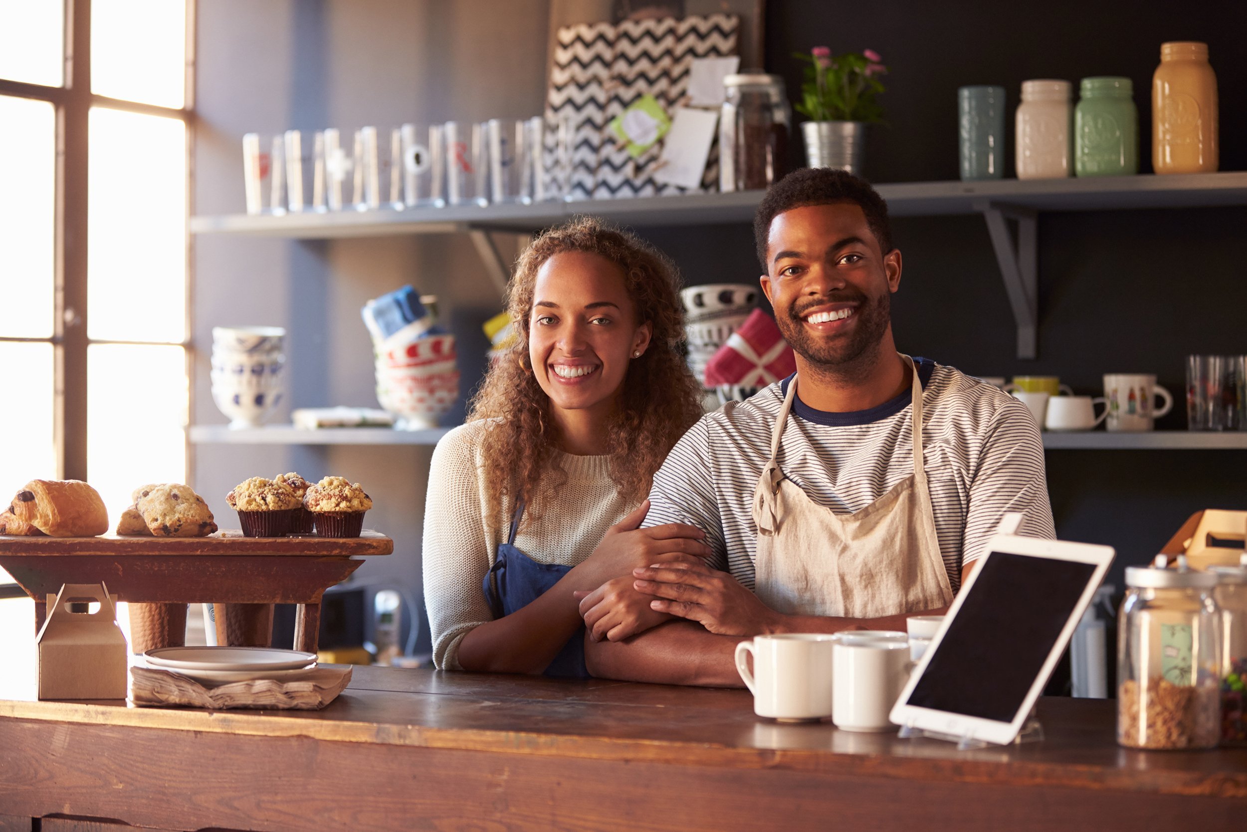 African American couple running coffee shop behind counter
