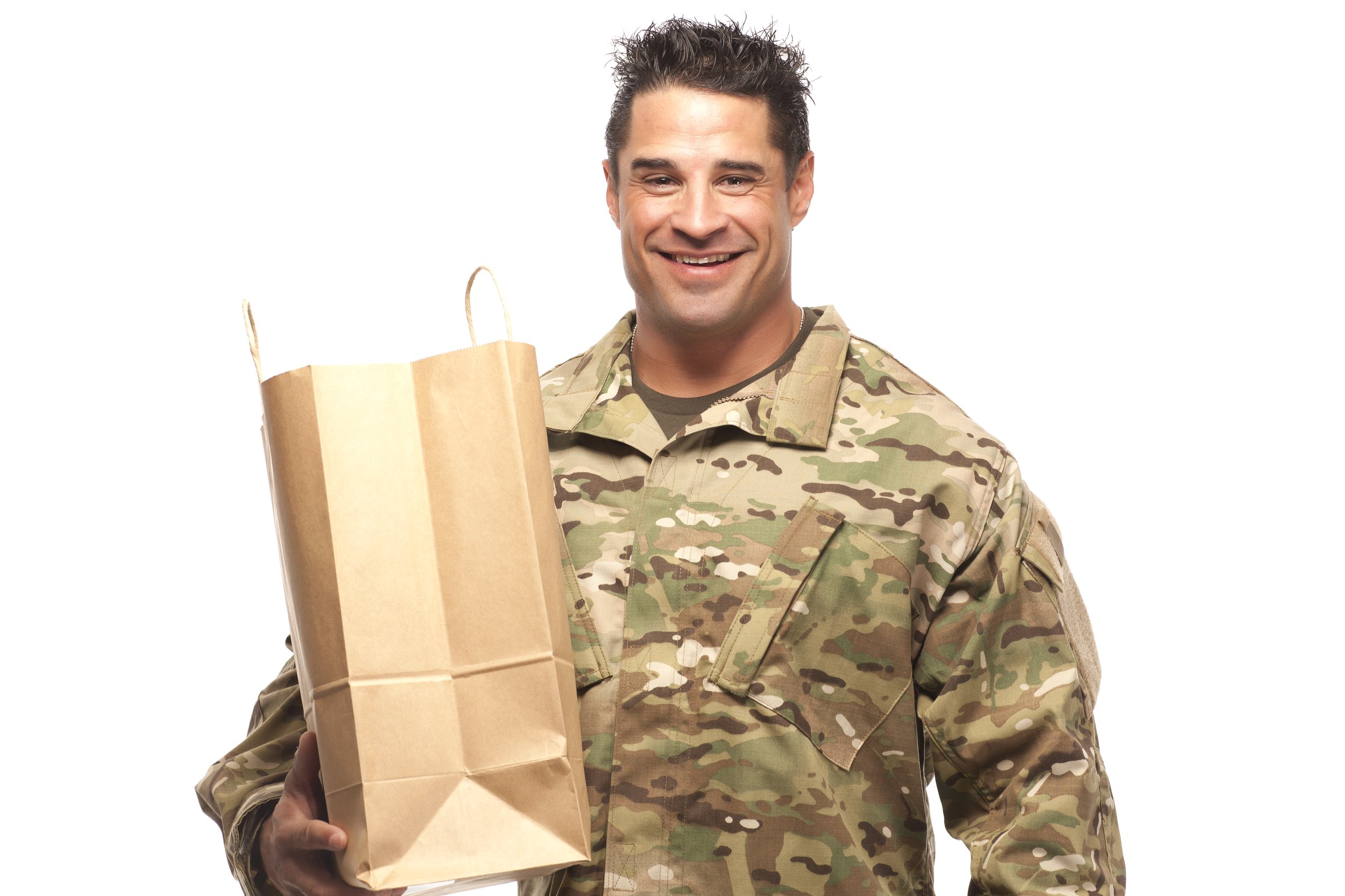 Smiling army soldier with shopping bag in front of white background