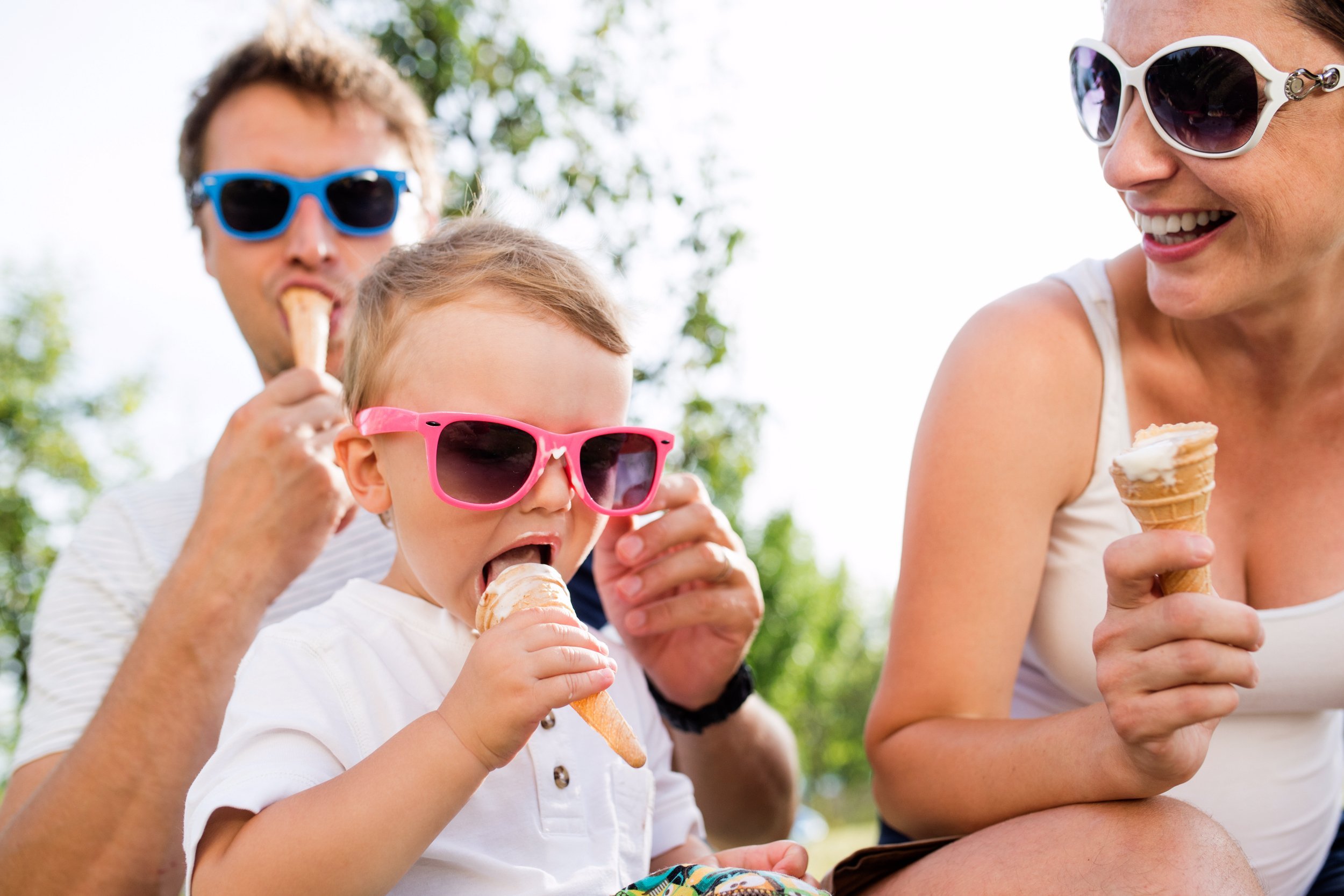 Father, mother and son eating ice cream, sunny summer