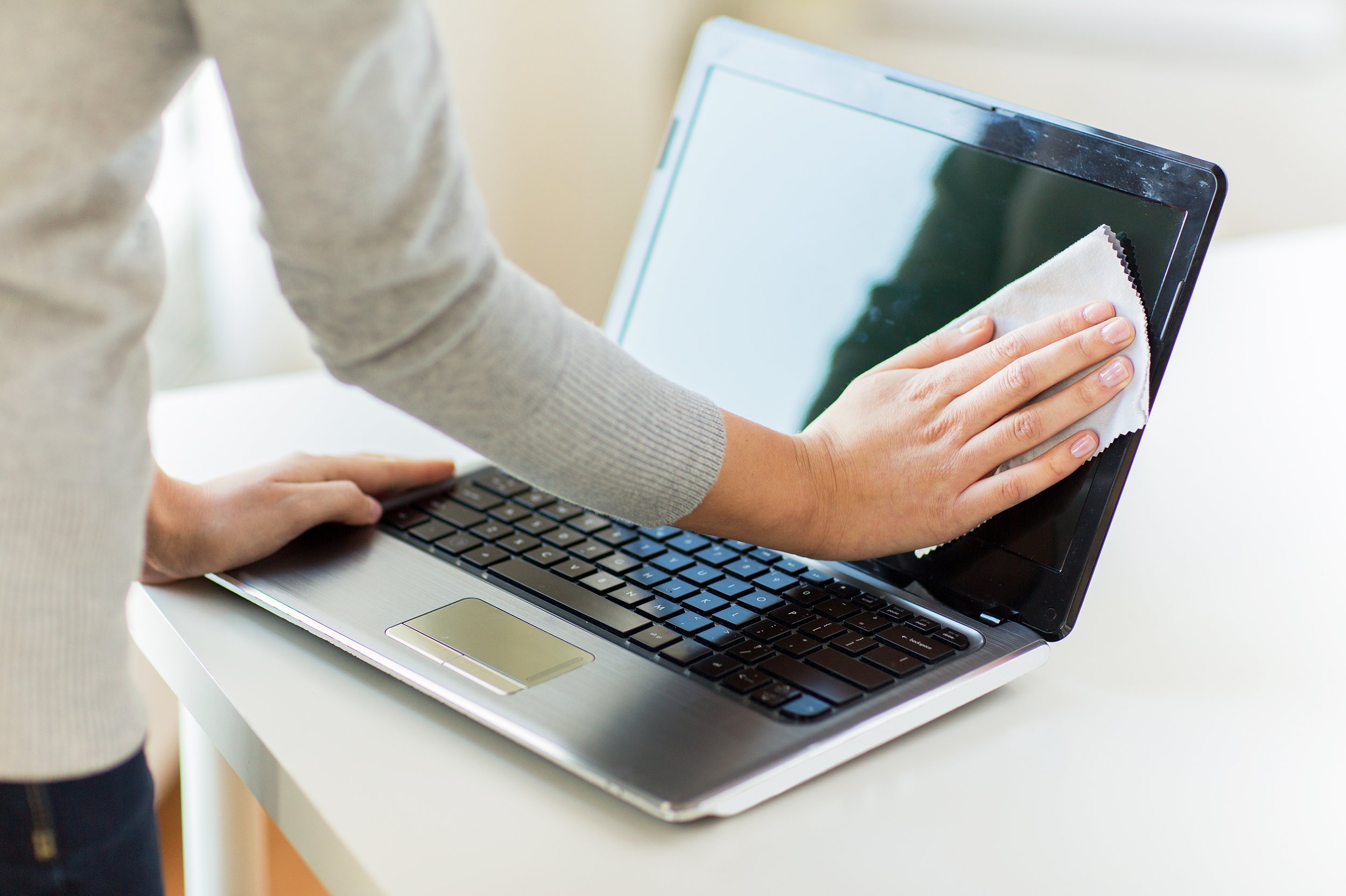 woman hands cleaning laptop computer screen with cloth