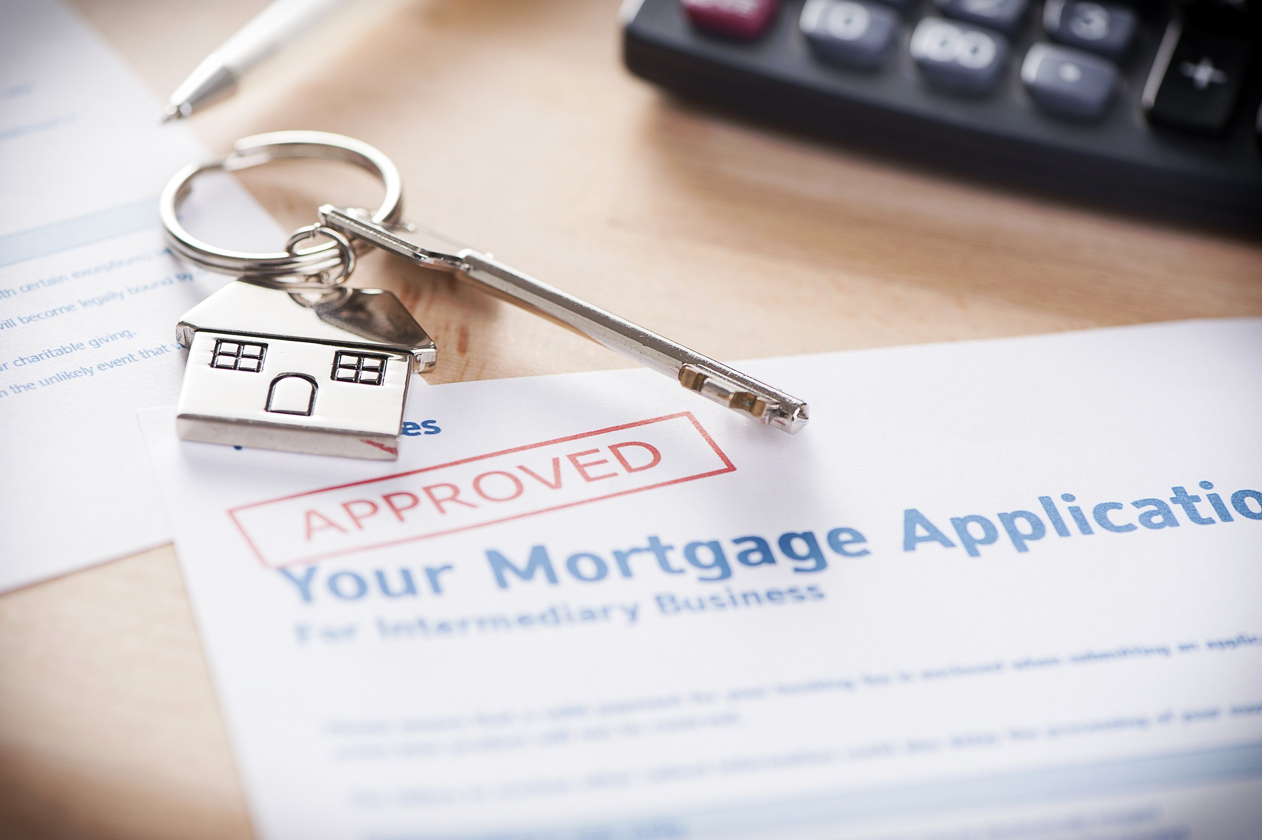 approved mortgage loan agreement application with house shaped keyring