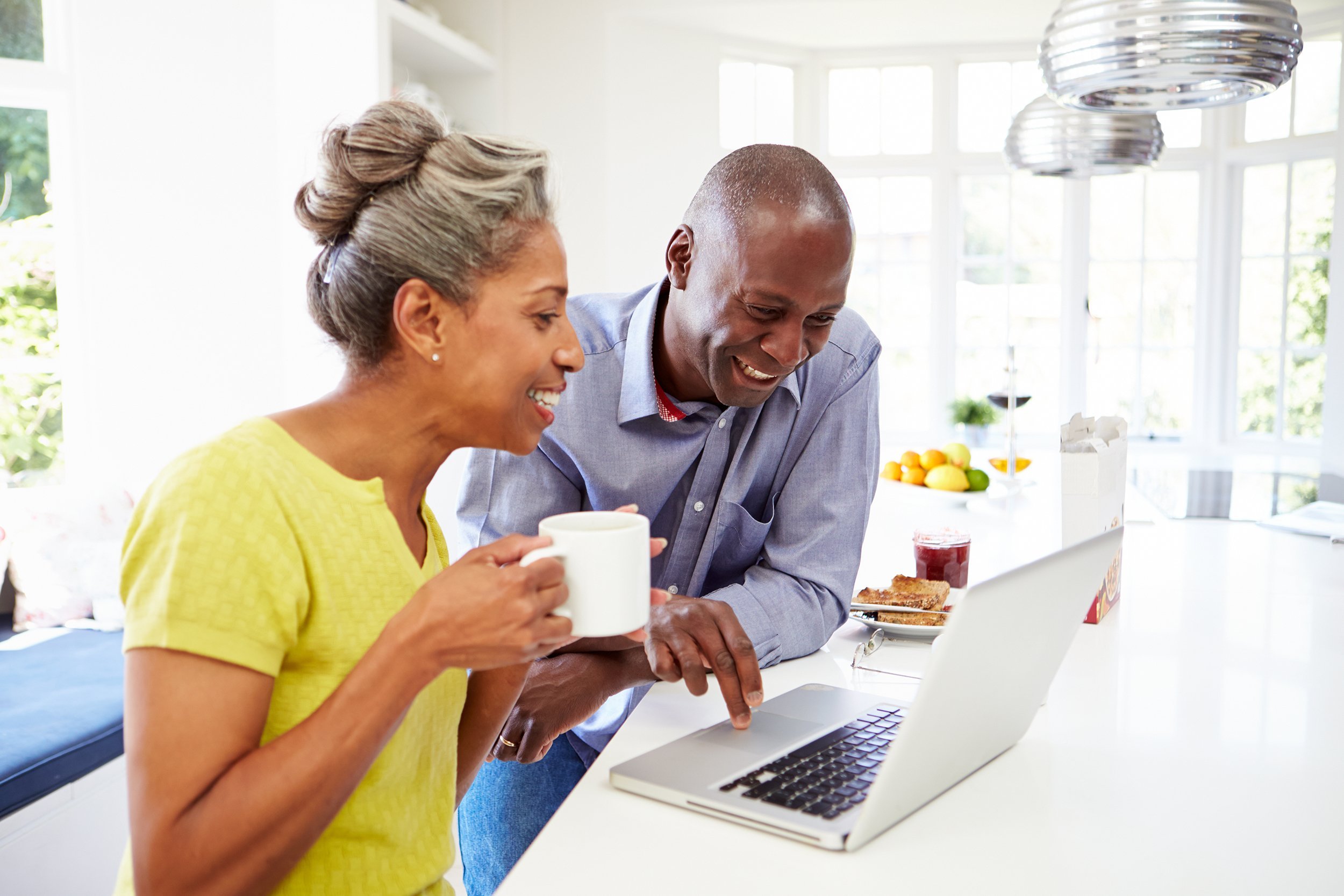mature African American couple using laptop at breakfast