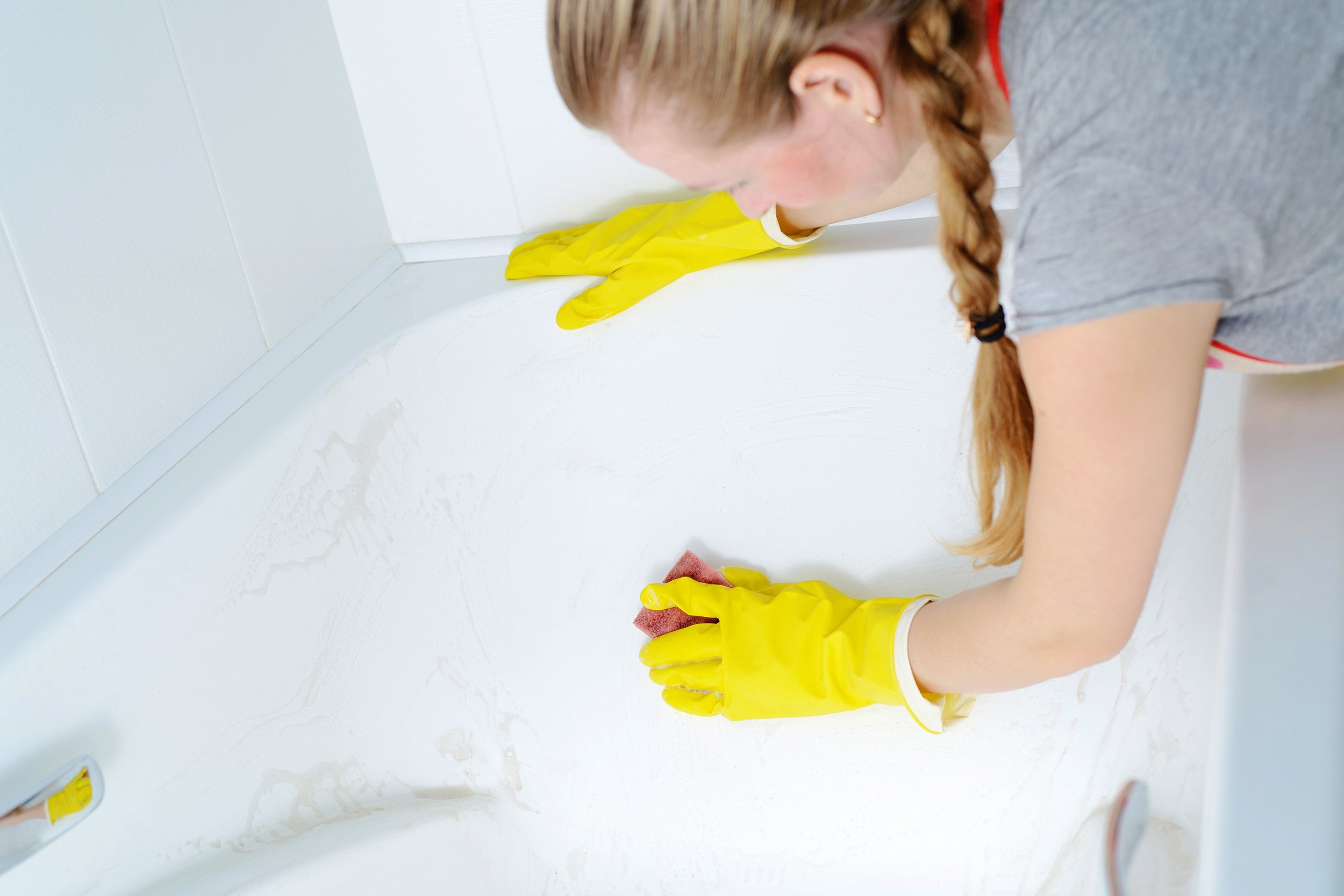 woman cleaning bath tub