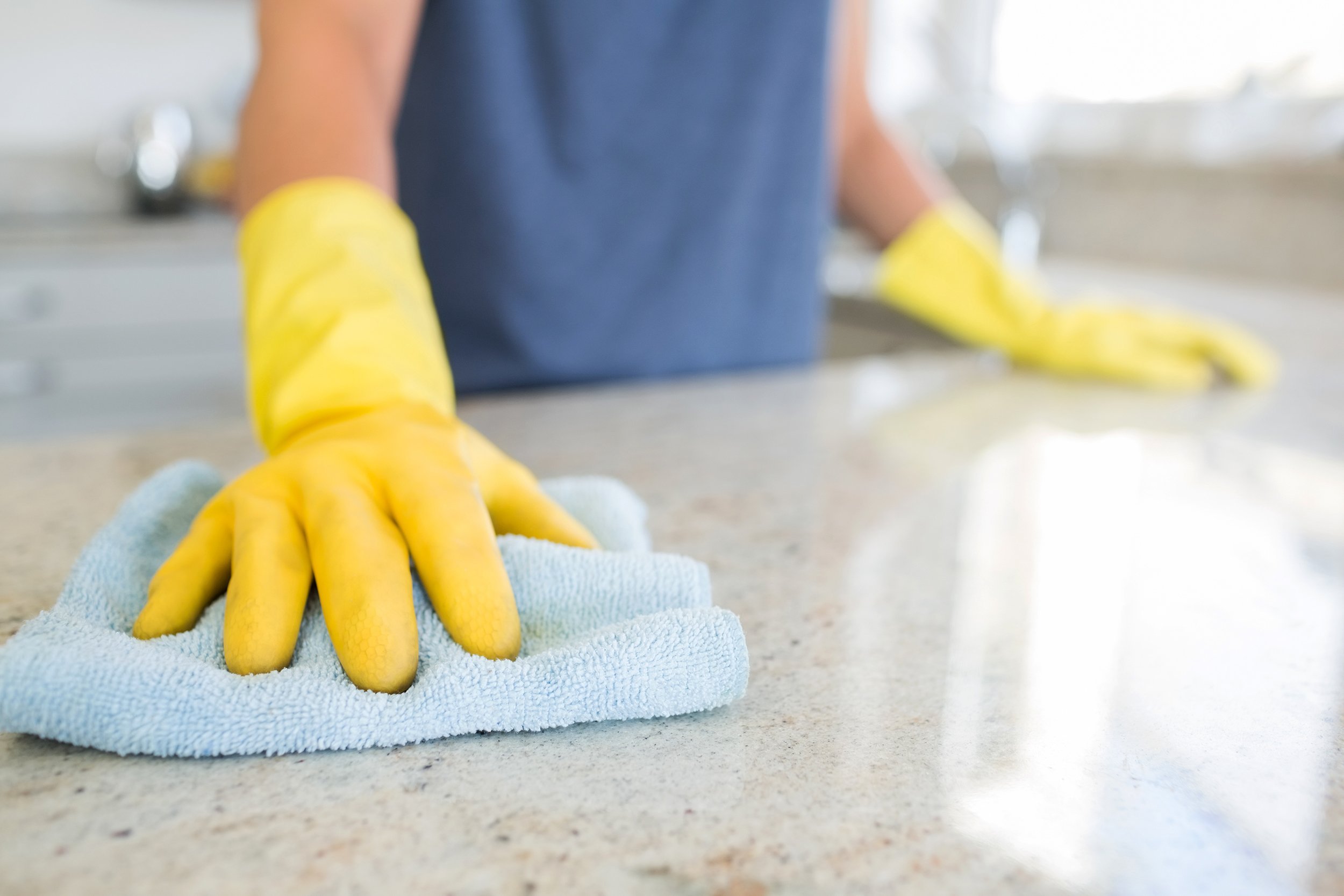 woman cleaning the counter in the kitchen