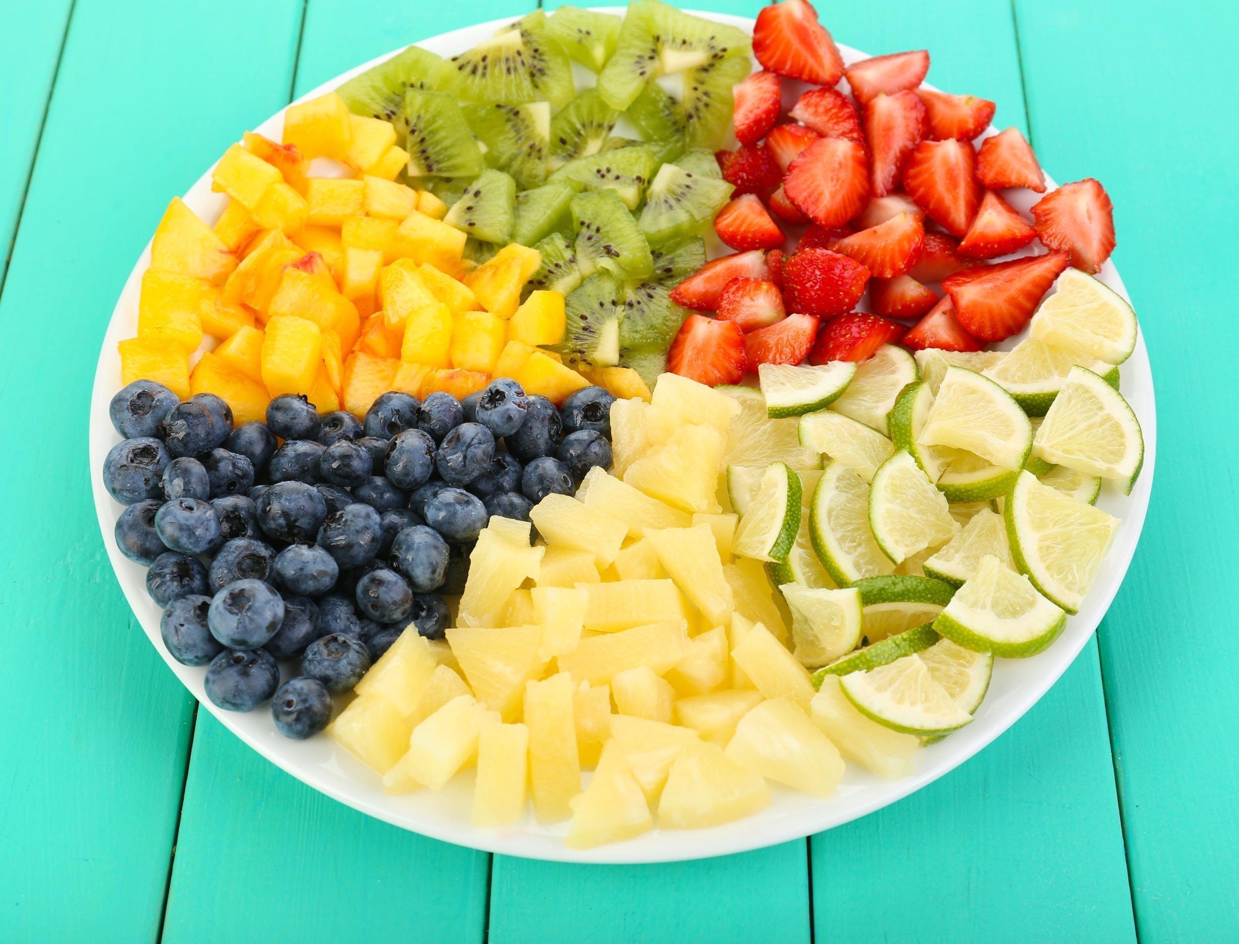 sliced fruits on plate on wooden table