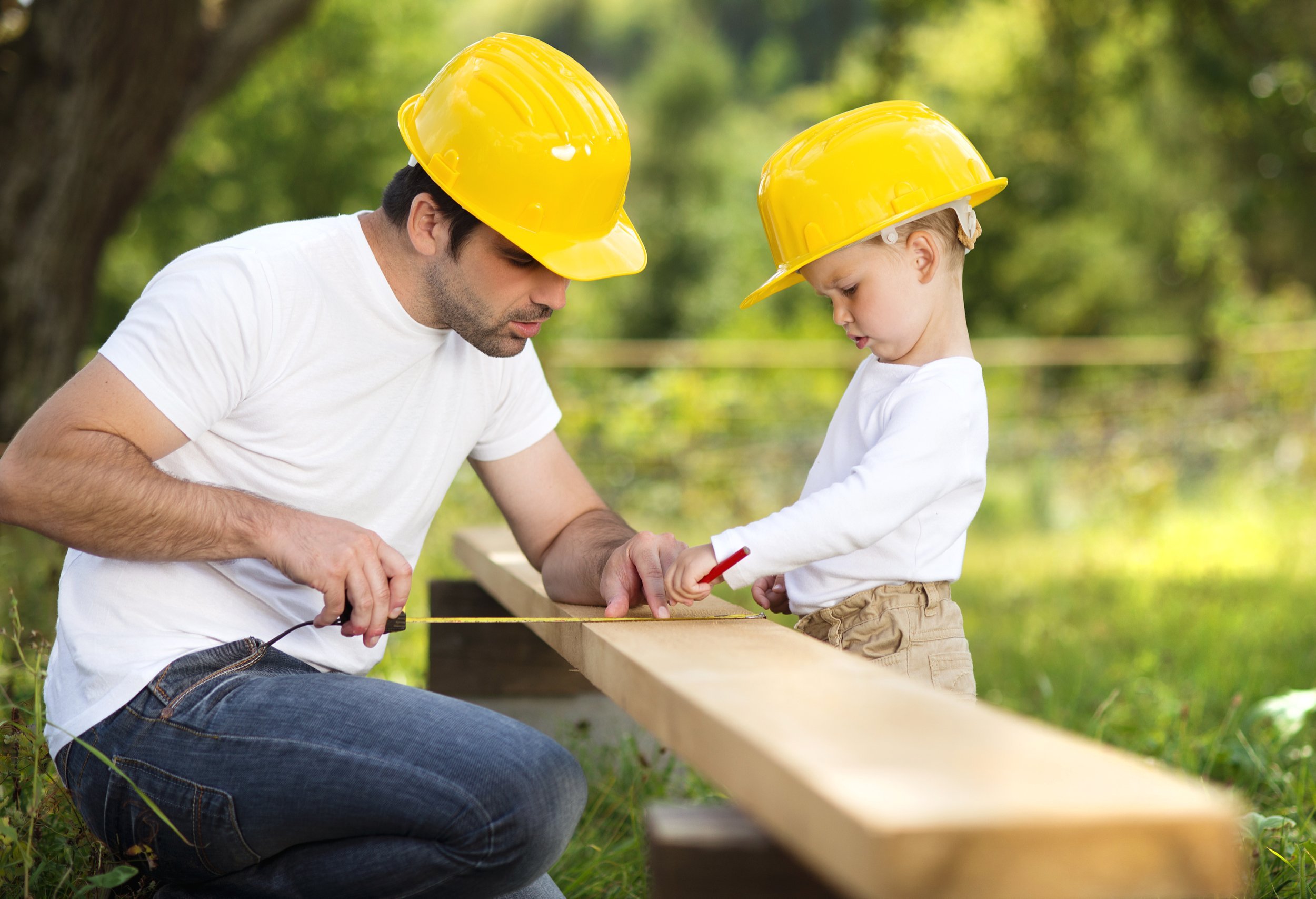Little son helping his father with building work