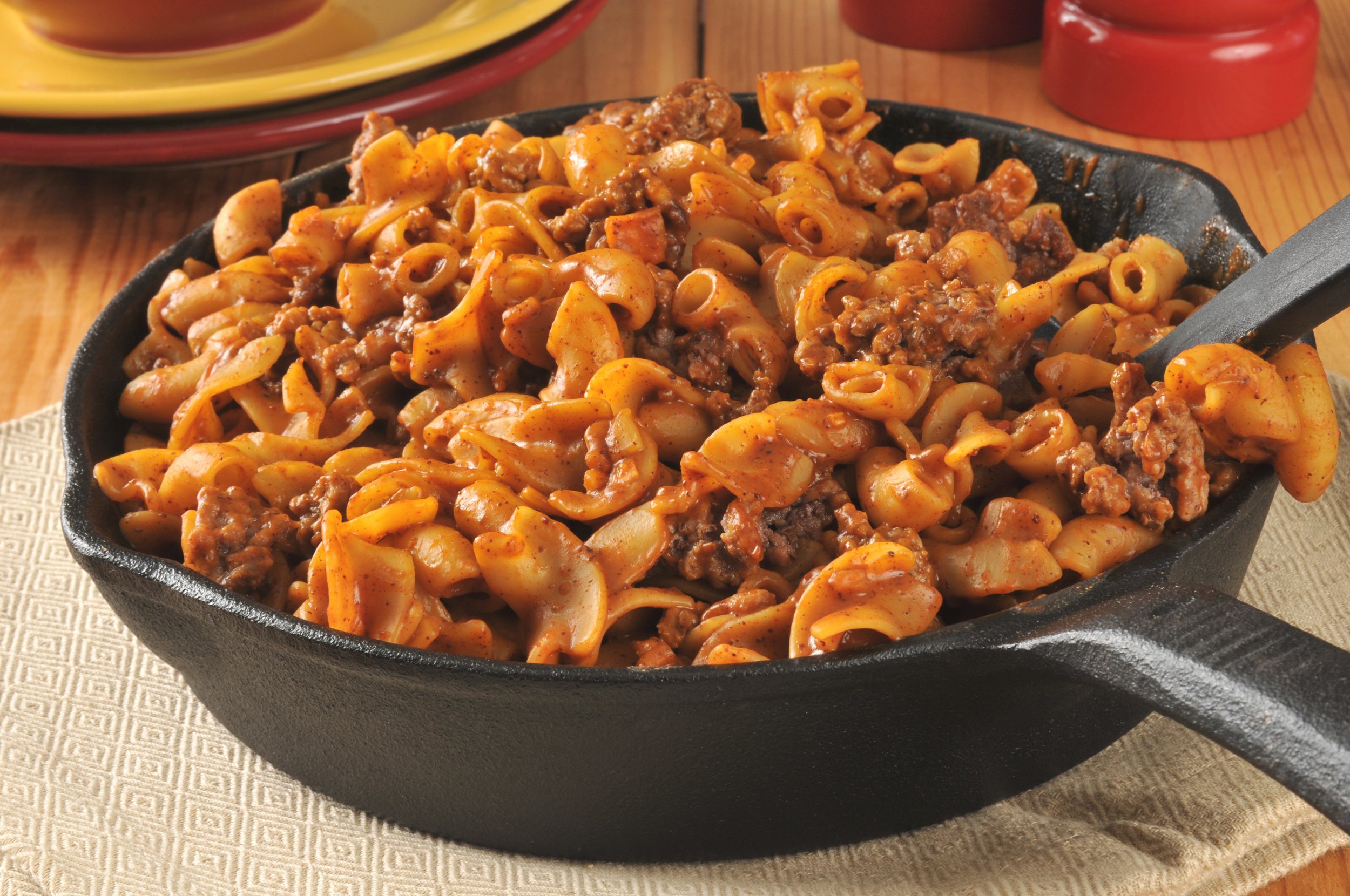 A hamburger chili macaroni casserole in a cast iron skillet