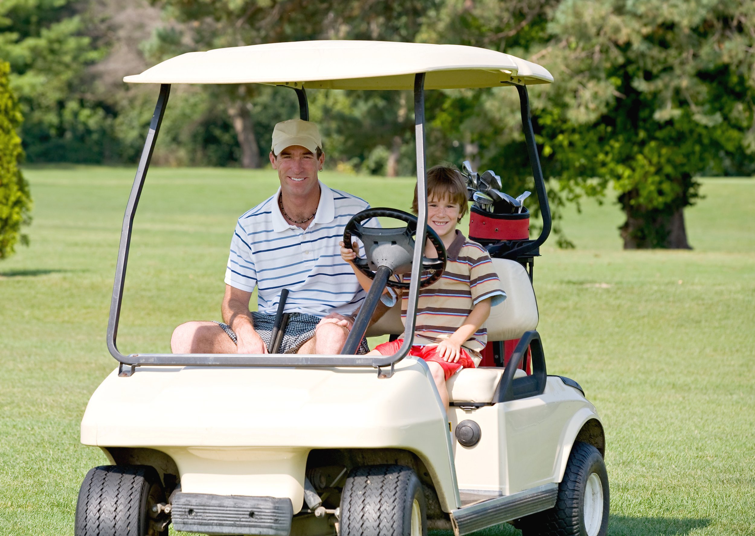 Father and son in golf cart