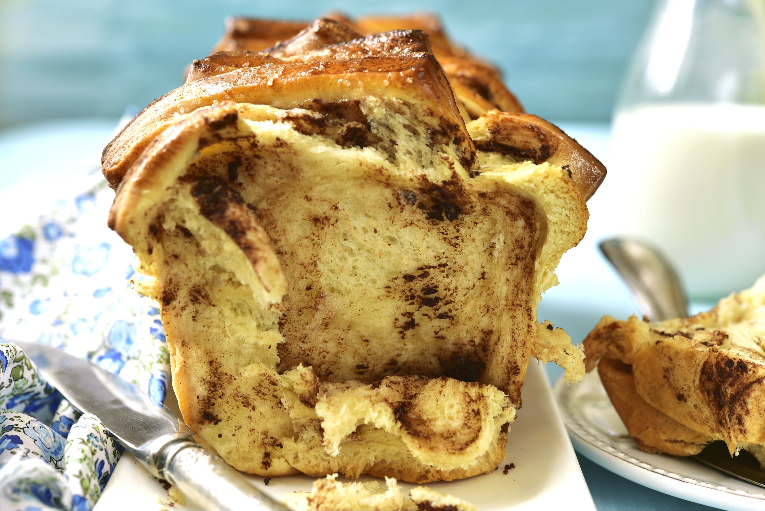 Pull-apart bread with cinnamon on turquoise background.