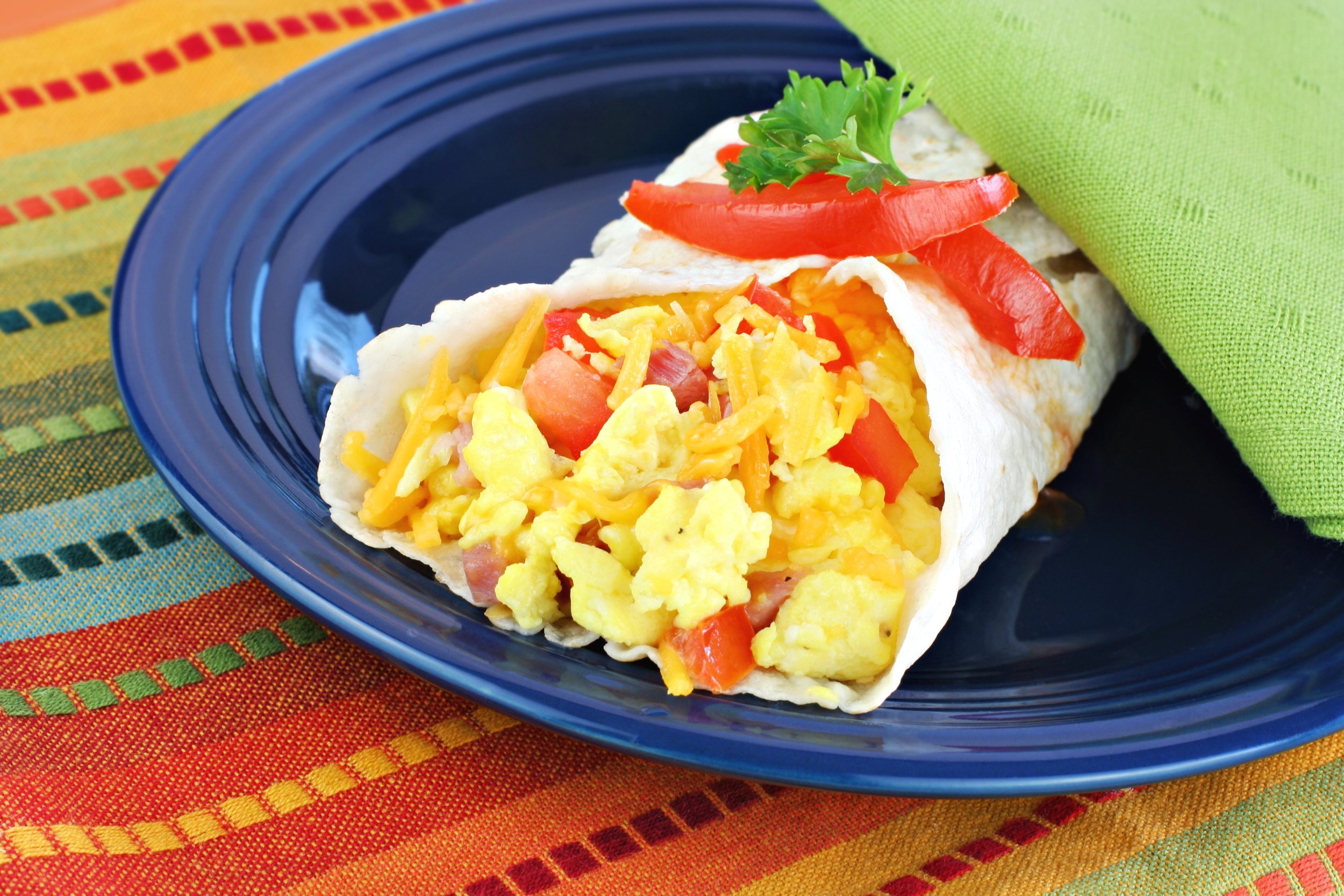 Delicious breakfast egg, tomato, cheese and pepper burrito