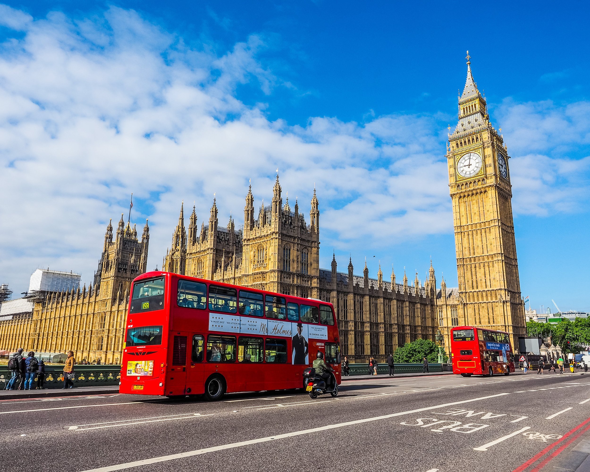 red bus going by Westminster Palace in London, United Kingdom
