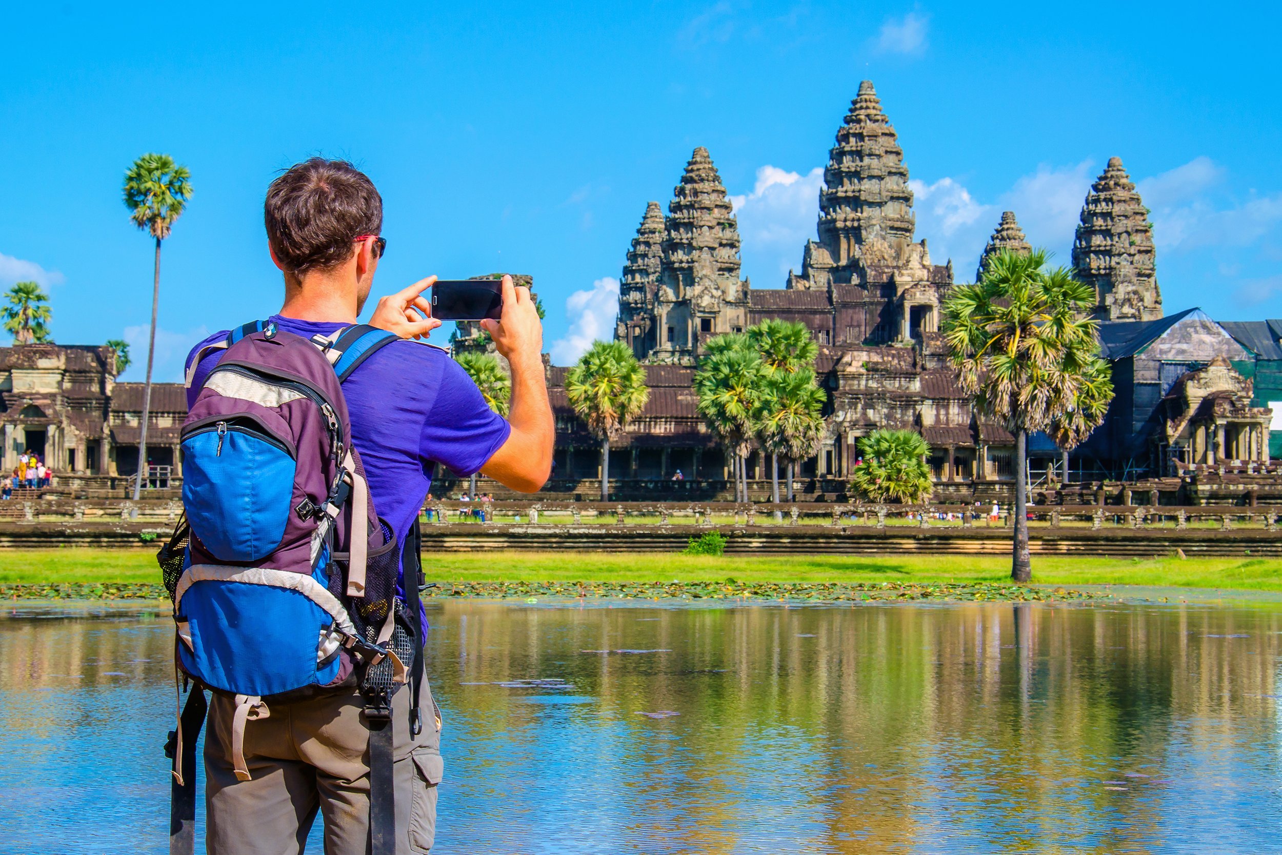 man is taking a photo of Angkor Wat temple, Siem Reap, Cambodia