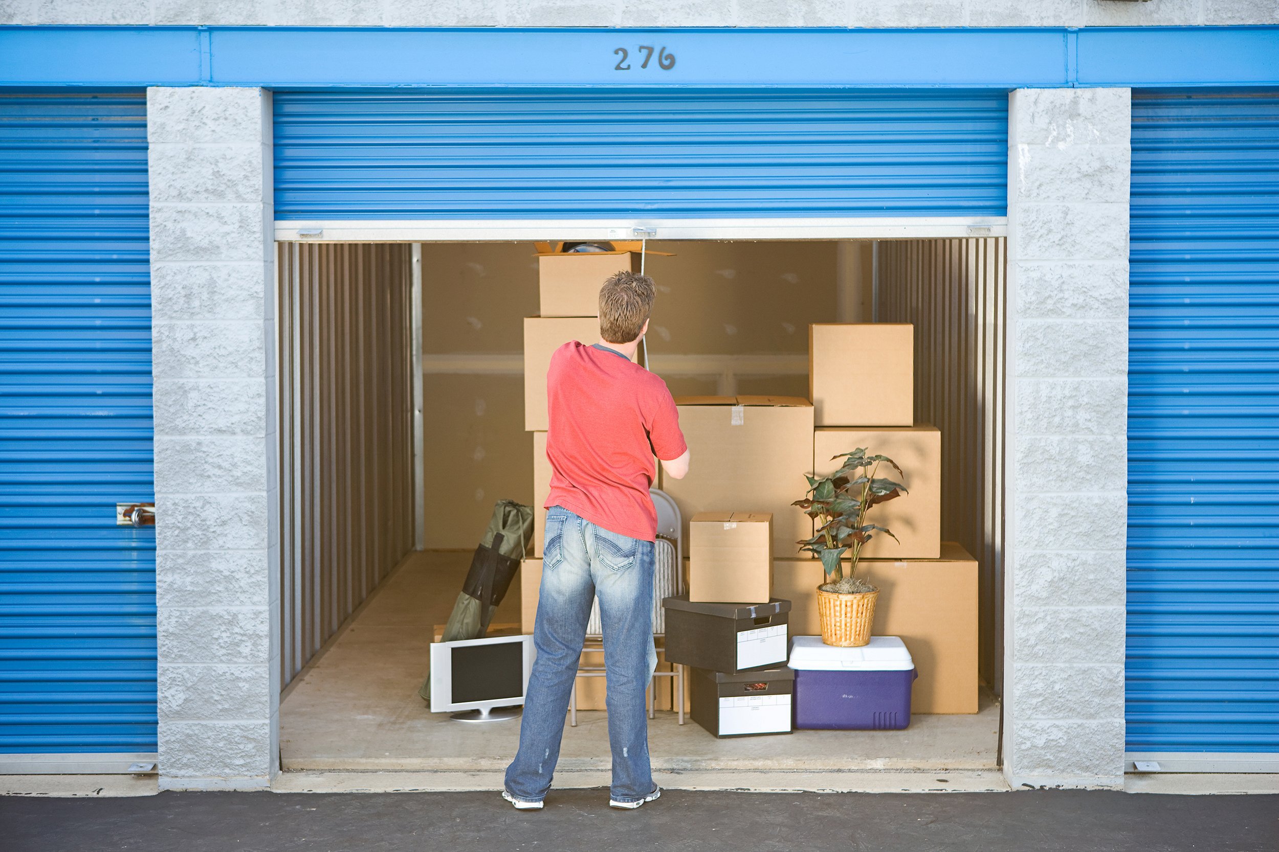 Man loading items in a storage shed