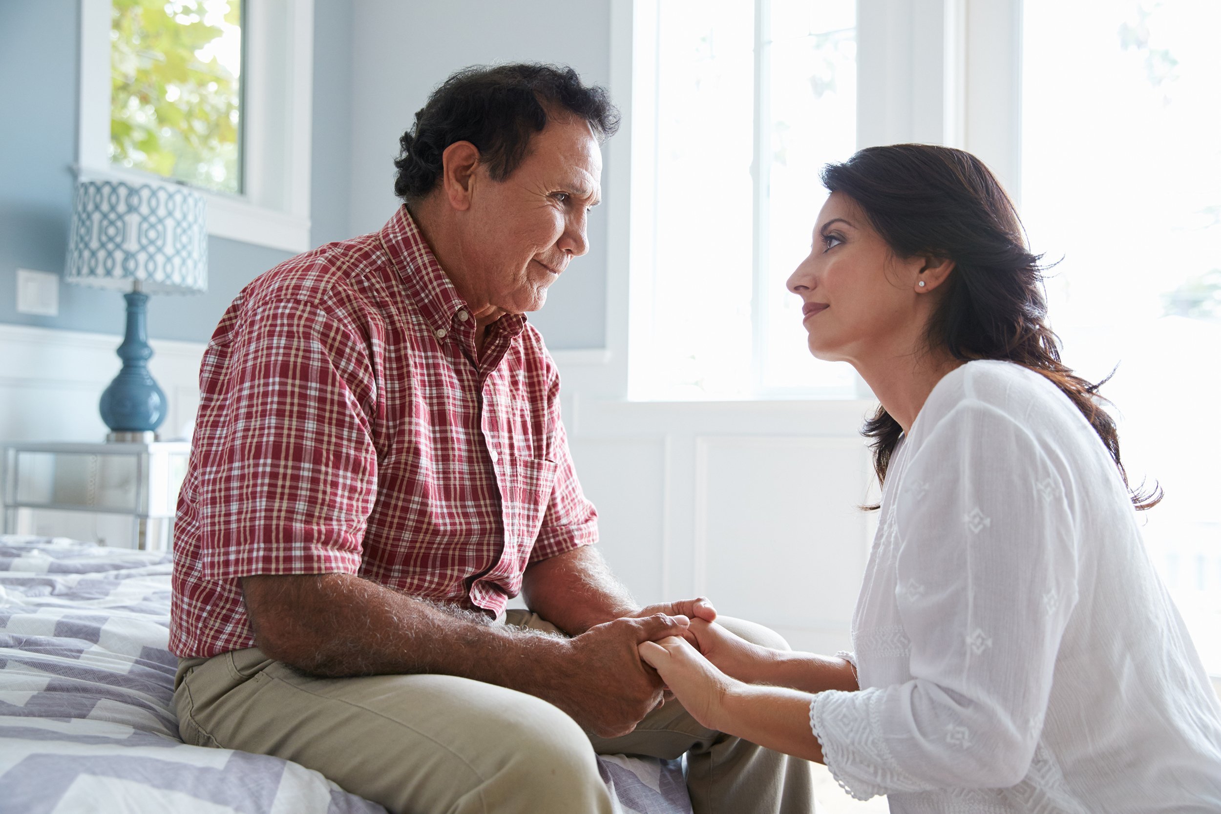 adult daughter comforting father suffering with dementia