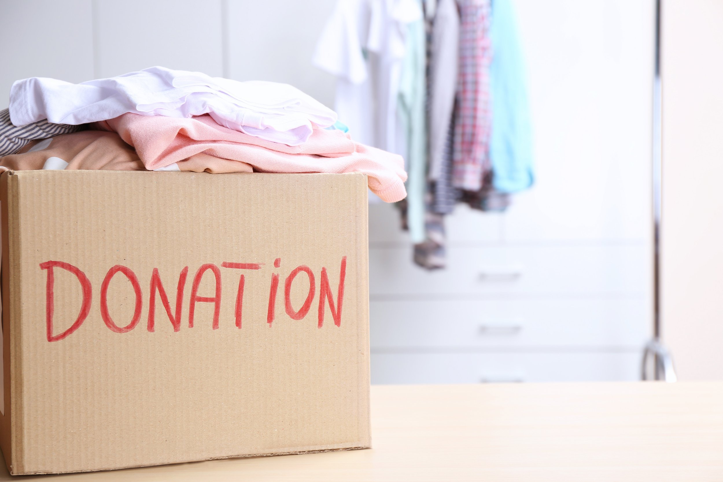Donation box with clothes on table in the room