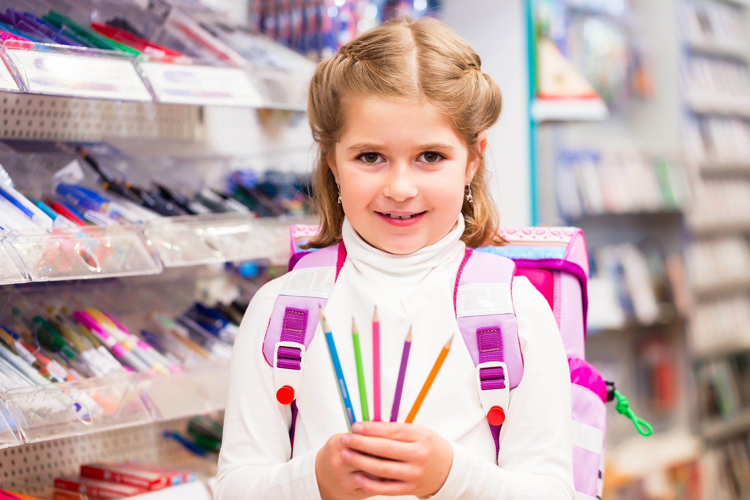 girl holding pencils at store