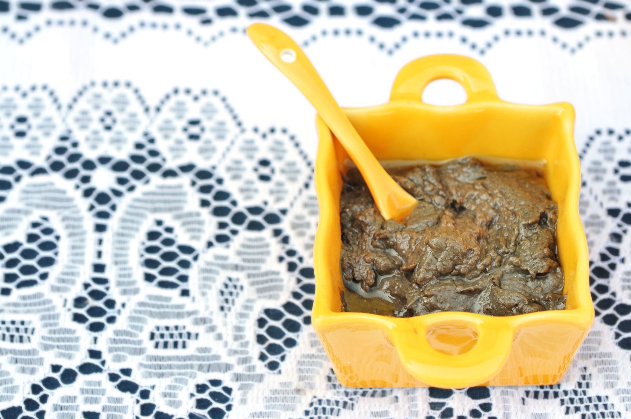 Traditional Provencal anchoiade (anchovy paste) in typical local yellow ceramic dish on white lace tableclothMore dips and speads here