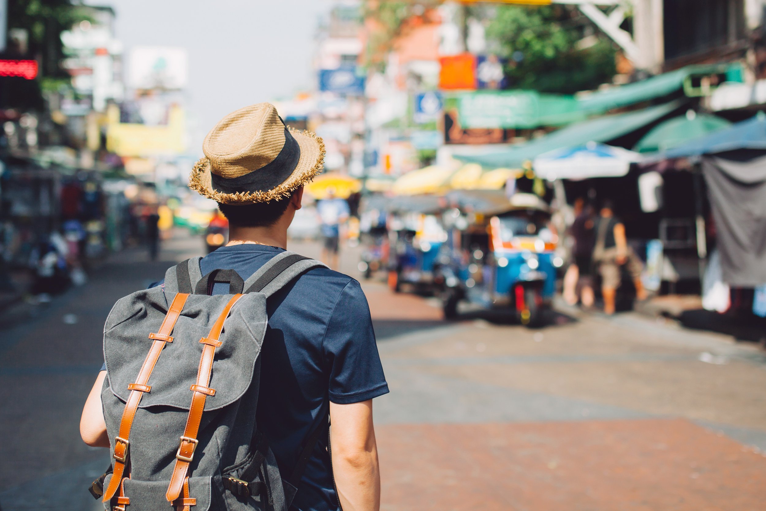 Asian traveling backpacker in Khaosan Road outdoor market in Bangkok, Thailand