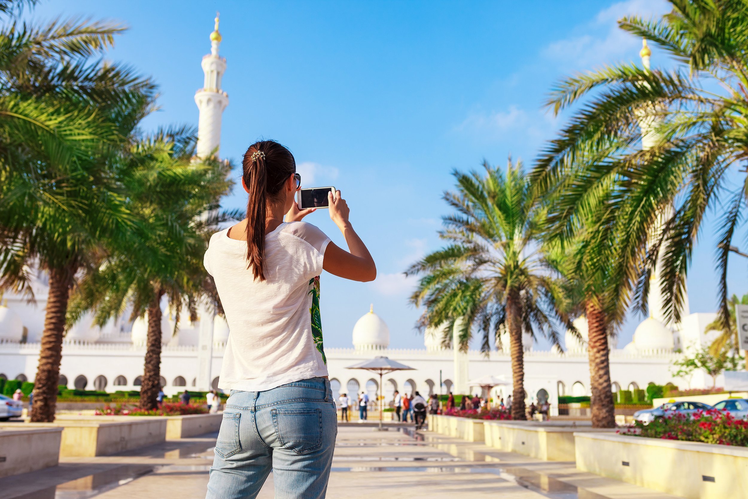 female tourist shooting on mobile phone Sheikh Zayed great white mosque in Abu Dhabi