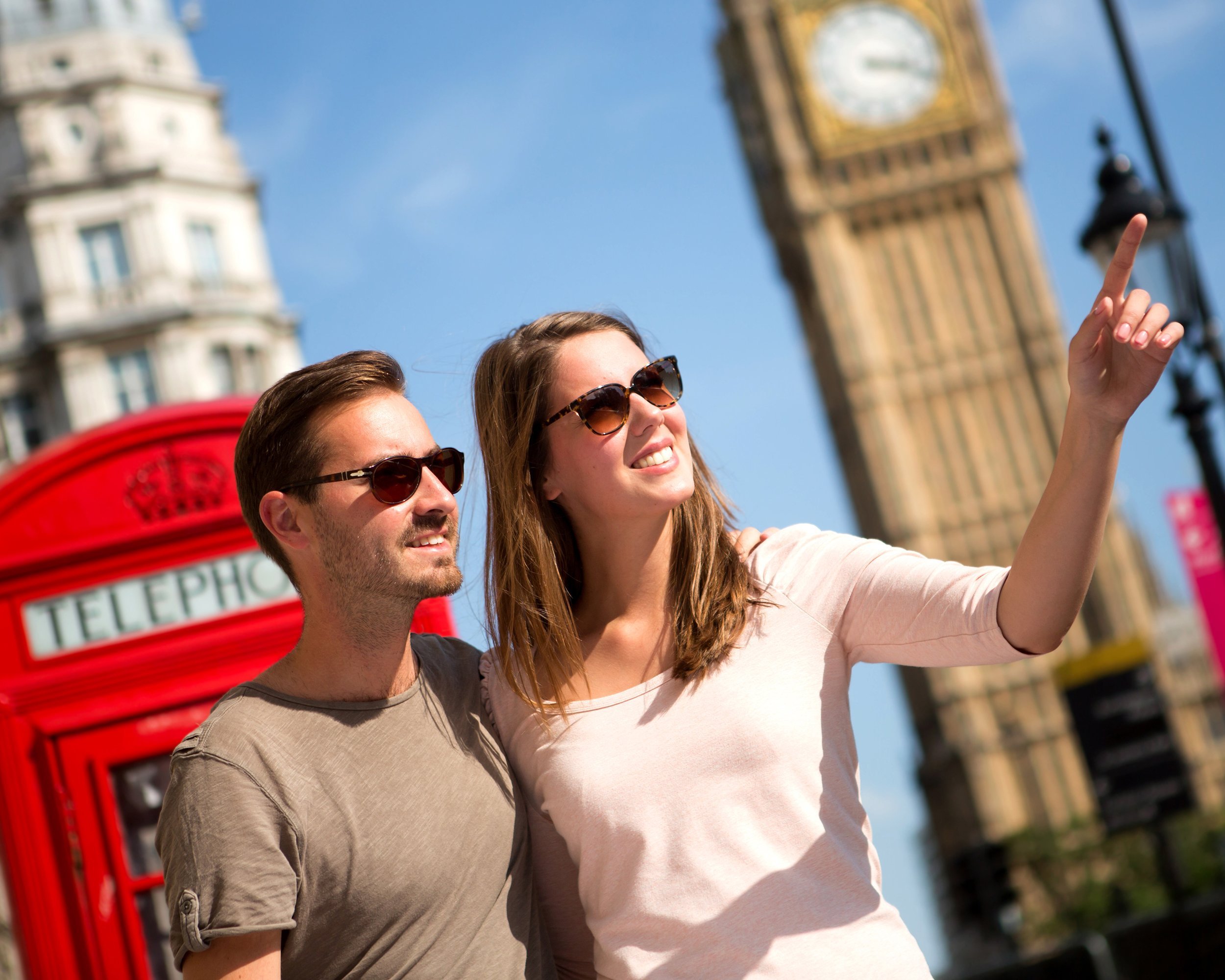 couple sightseeing in London pointing away near the Big Ben