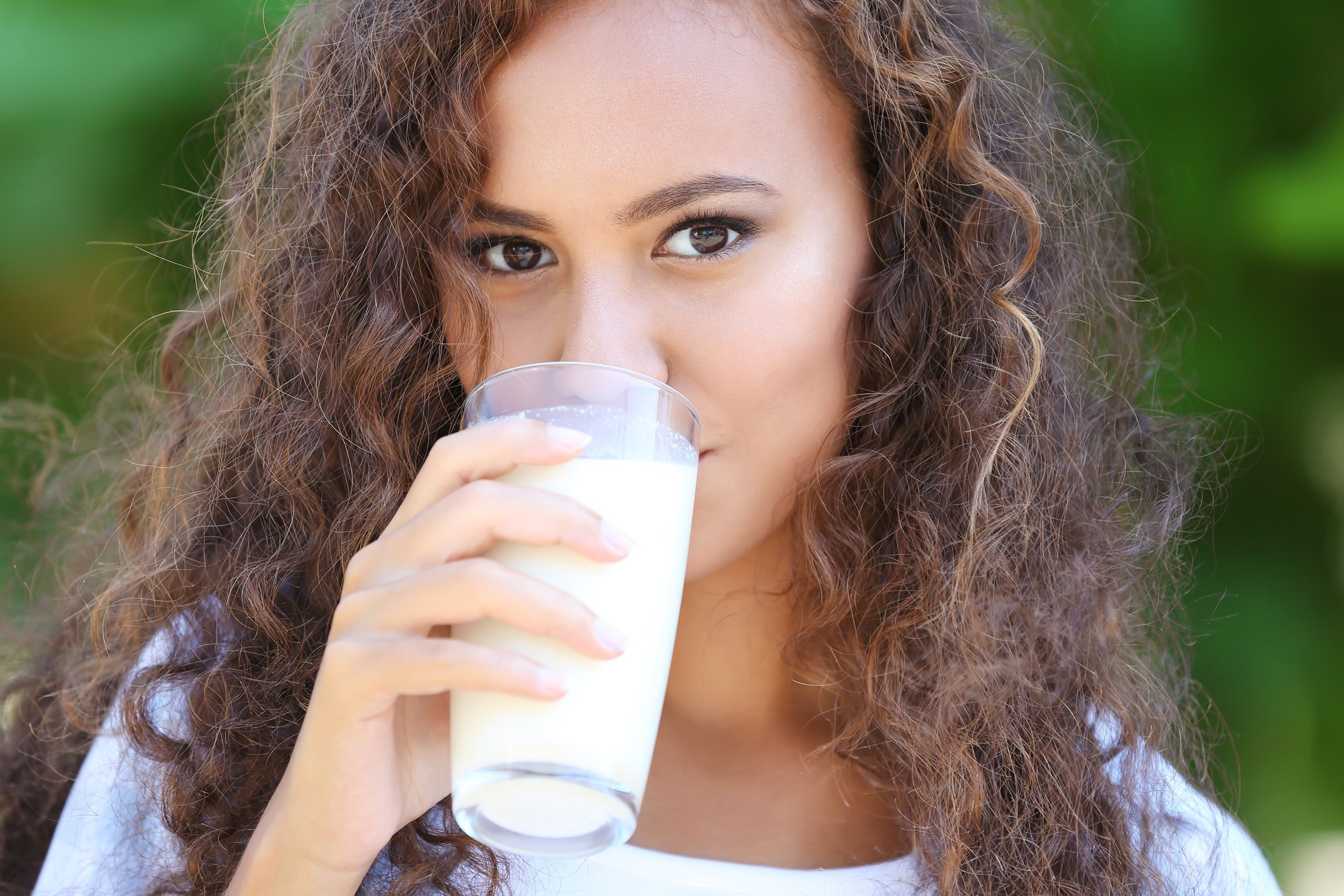 young African-American woman drinking milk outside