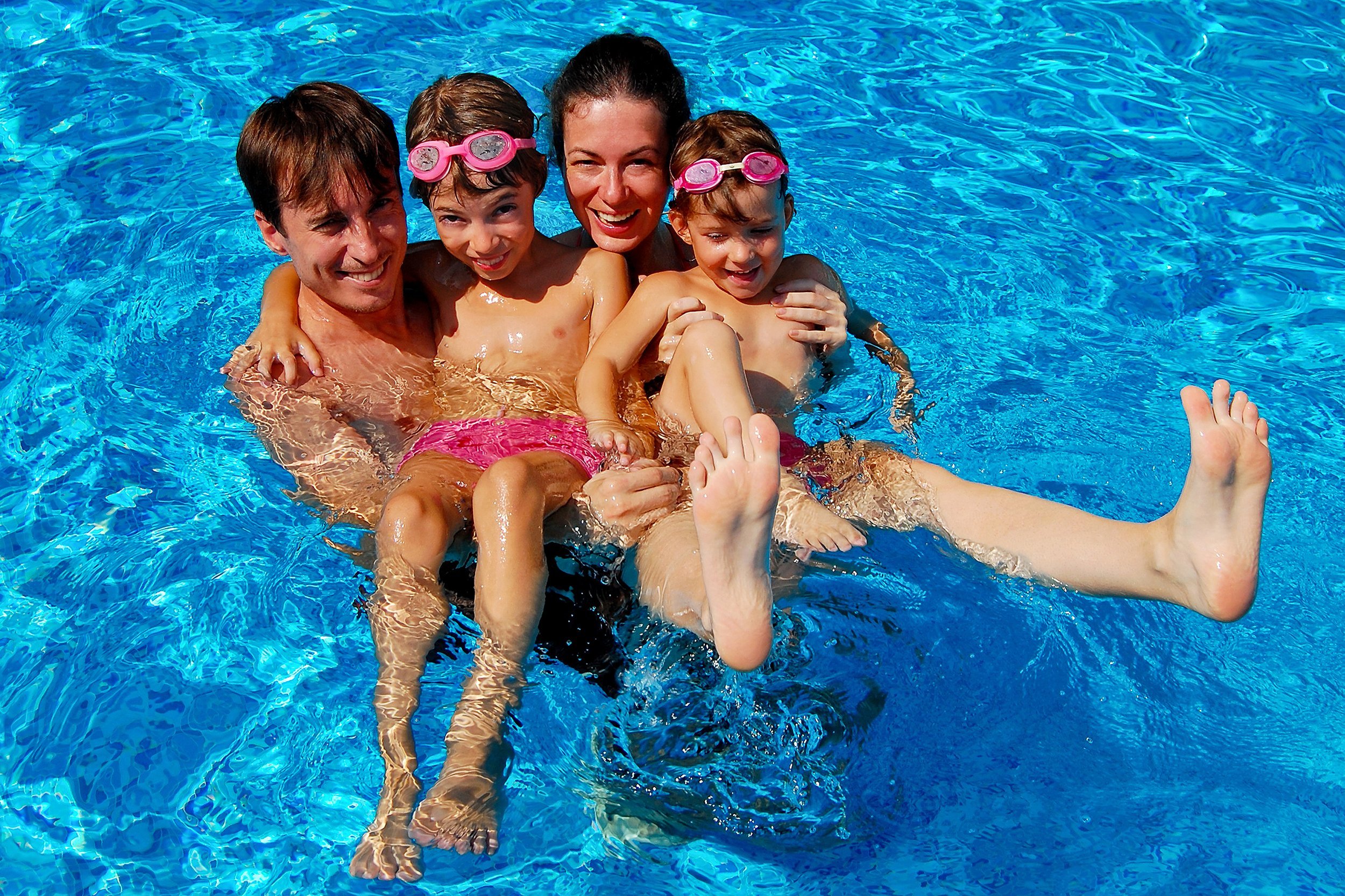 happy family with kids having fun in swimming pool