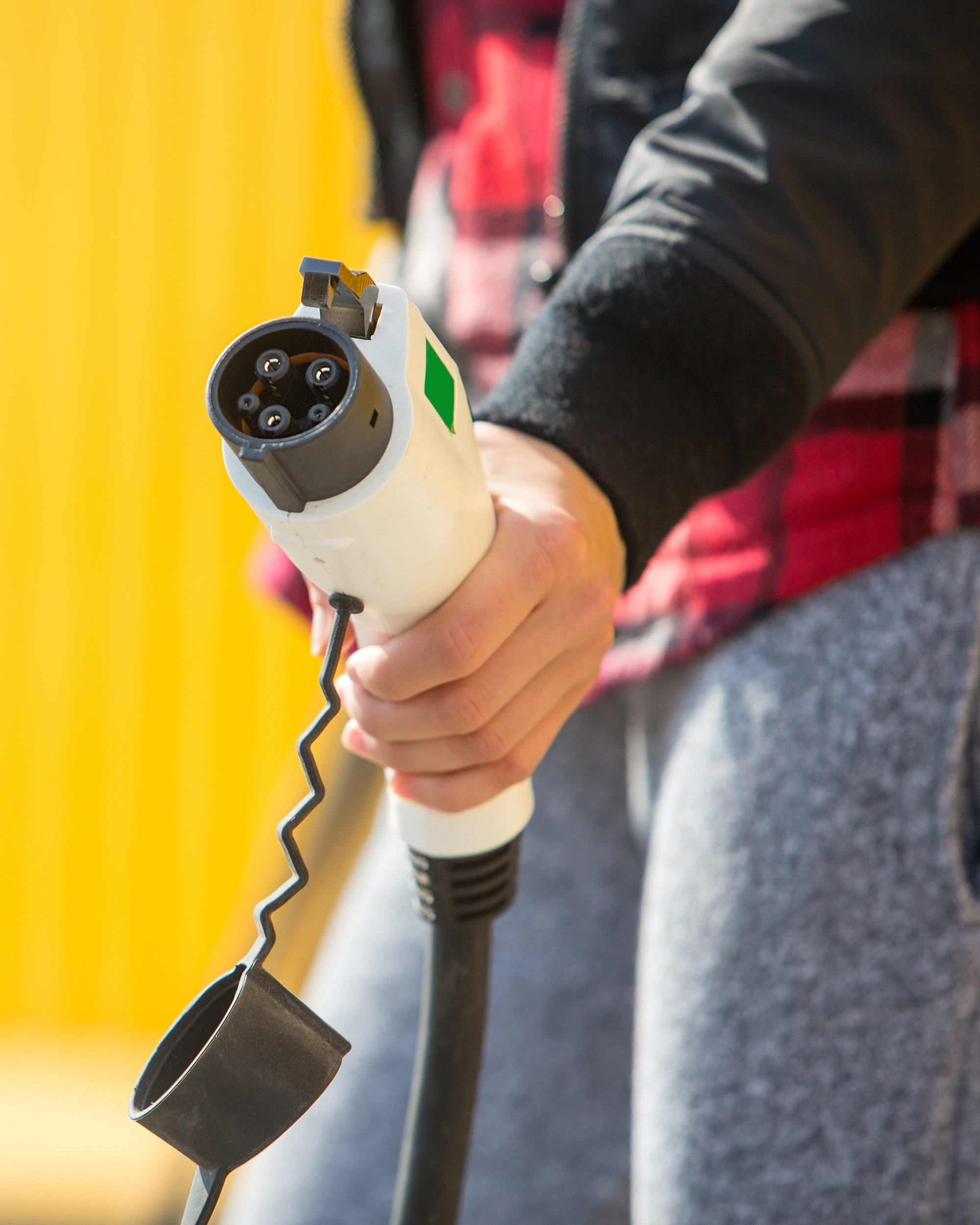 woman charging electric car on charging station
