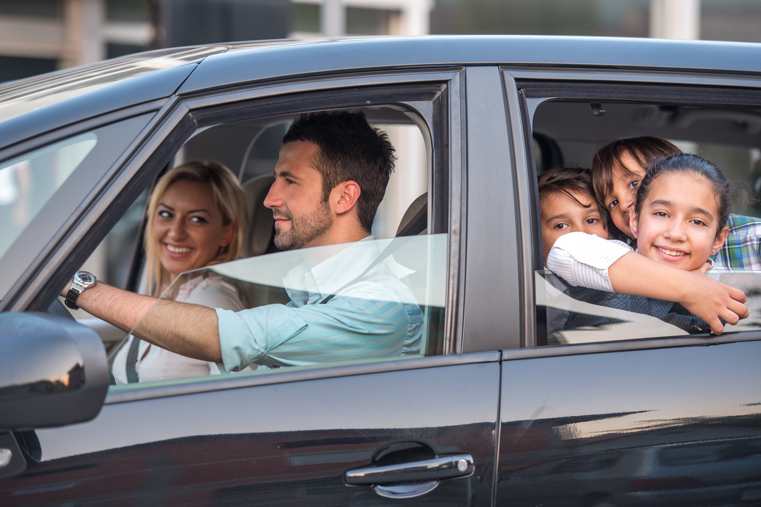 outside view of a beautiful family driving in automobile