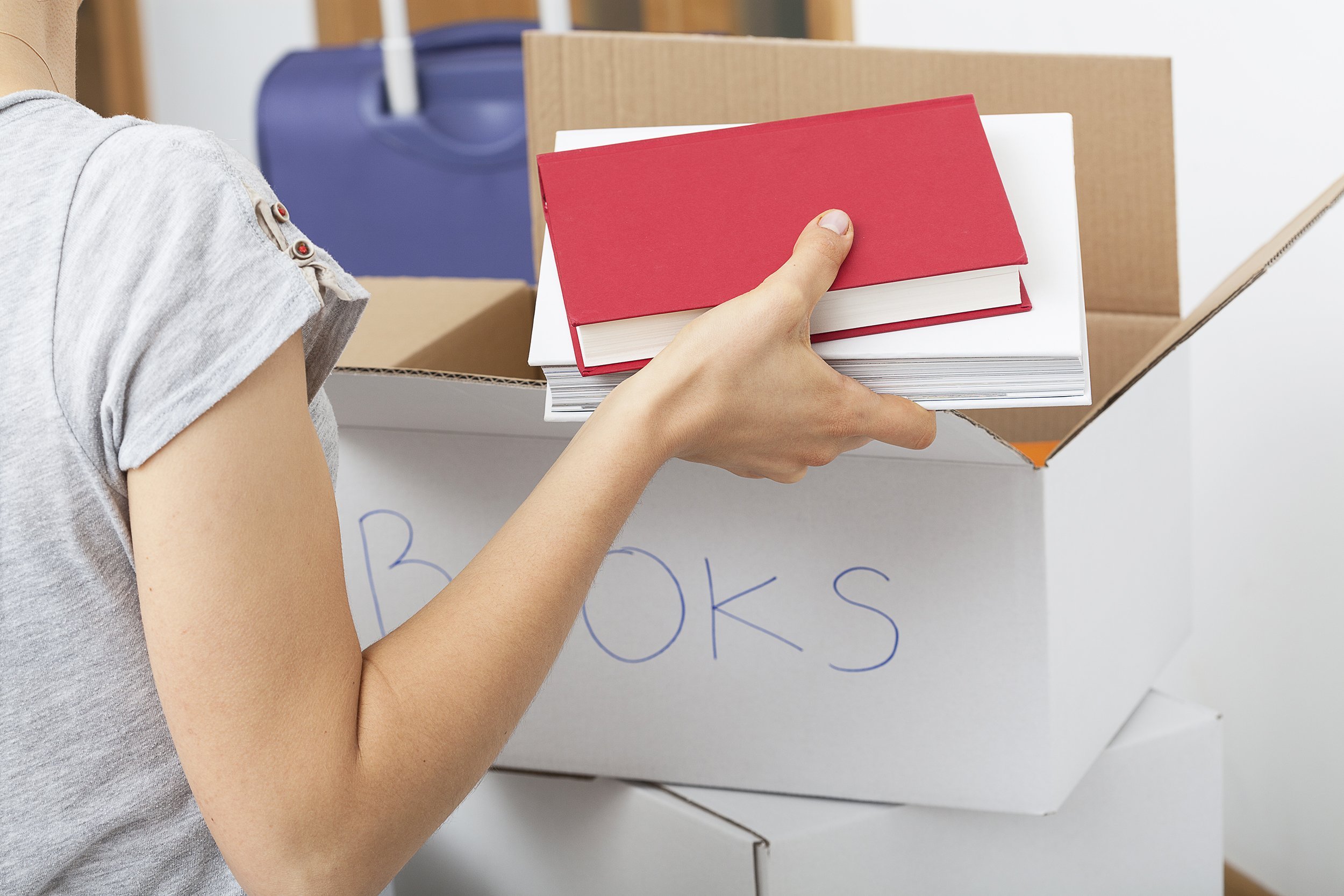 woman packing books in a box for a move