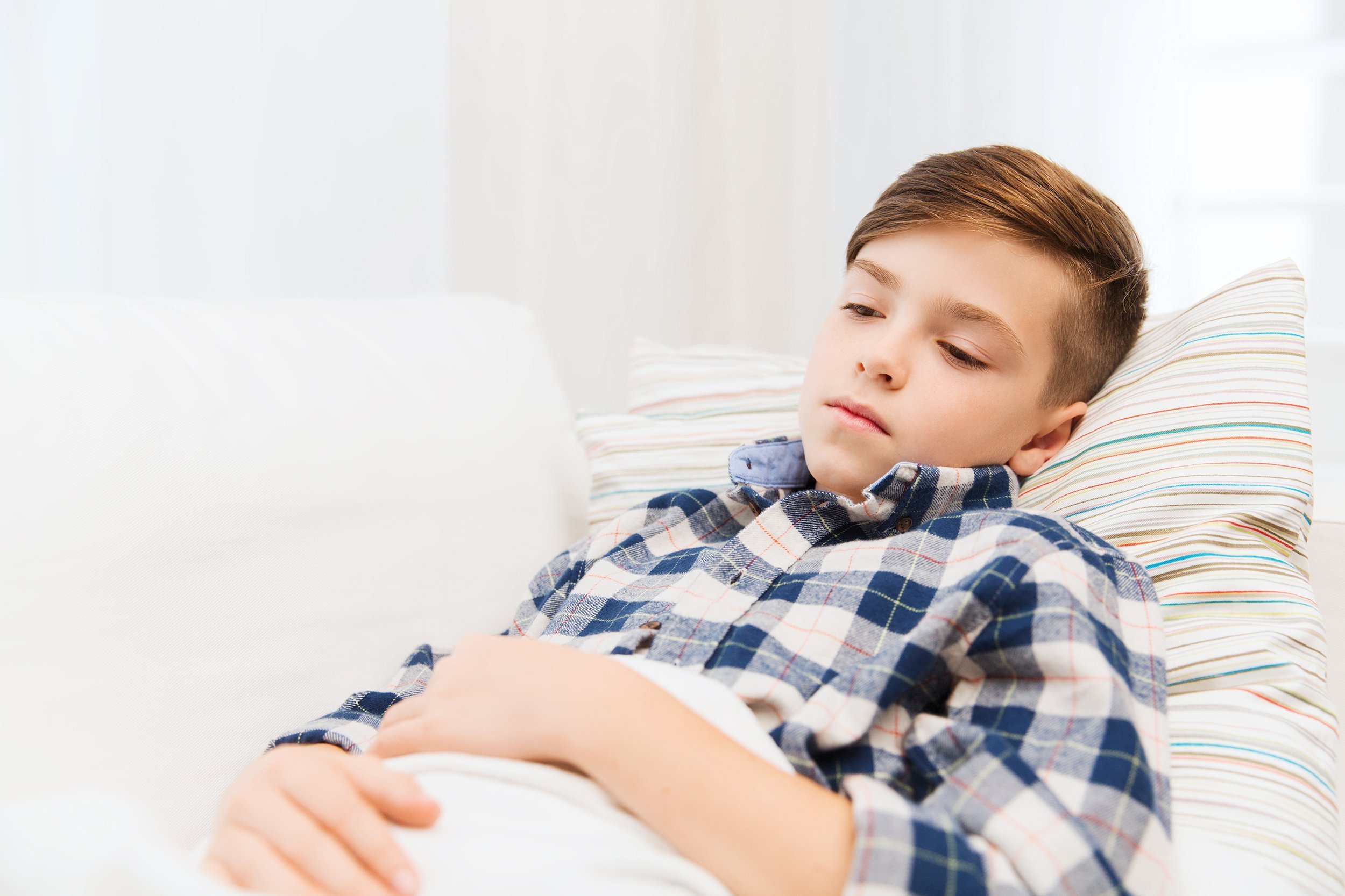 little boy on couch with a stomach ache