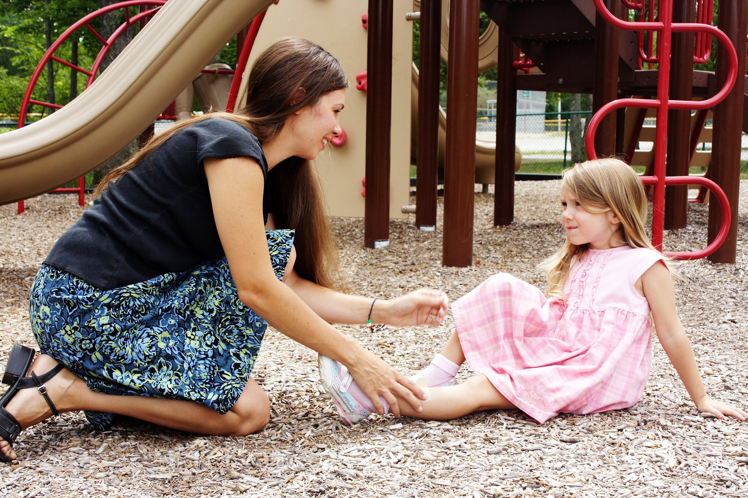 teacher helping injured girl on playground