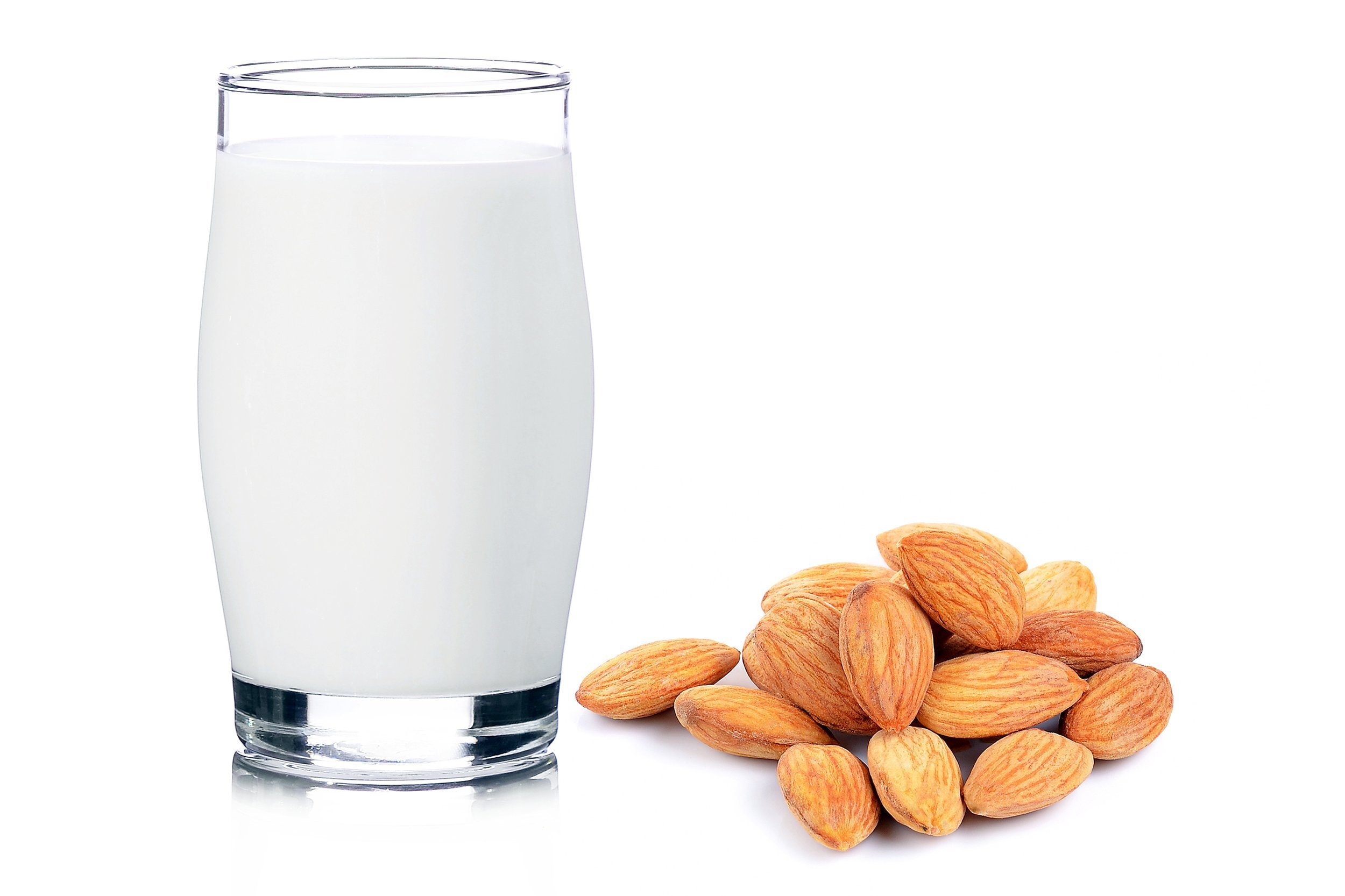 Glass of fresh almond milk next to almonds