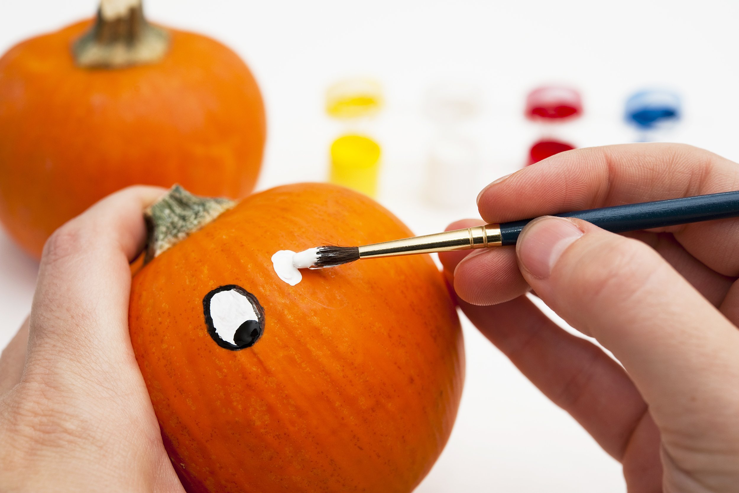 painting the eyes on a pumpkin