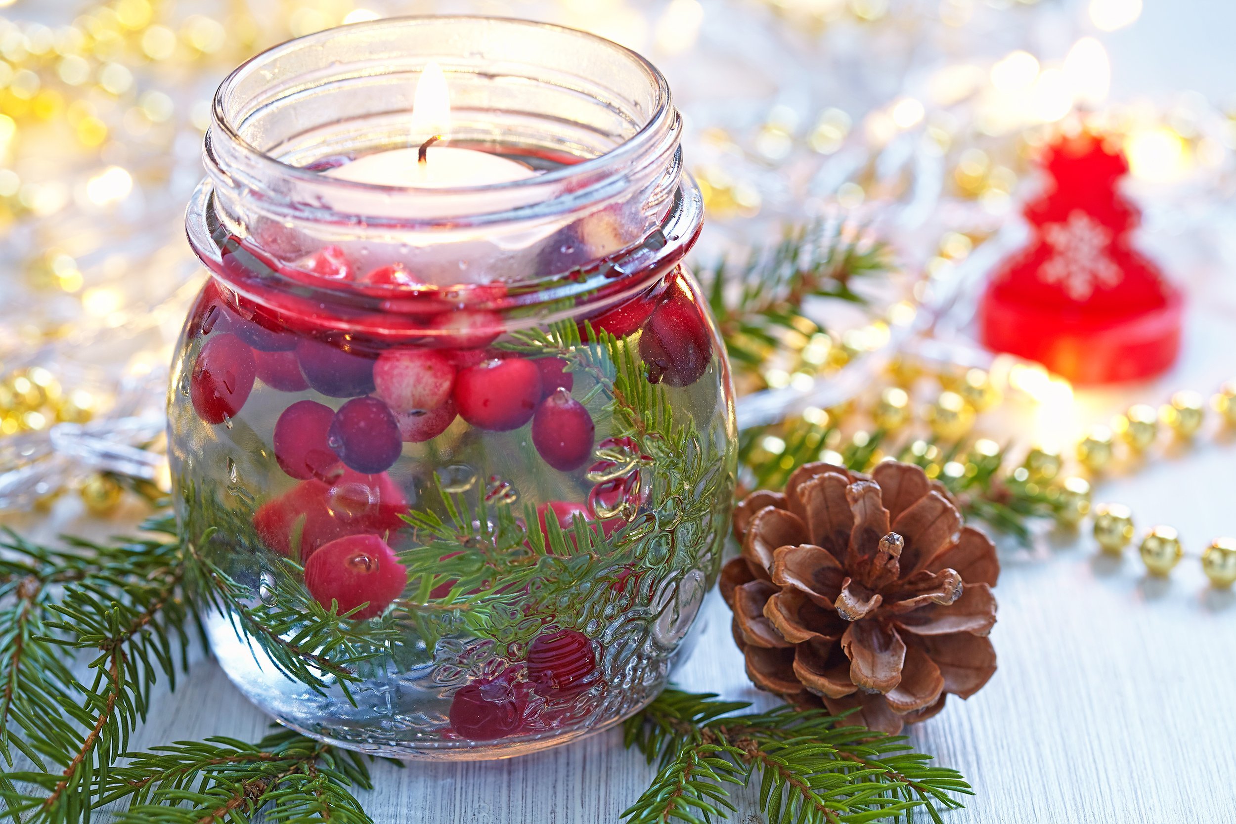 candle in glass jar with cranberry and fir
