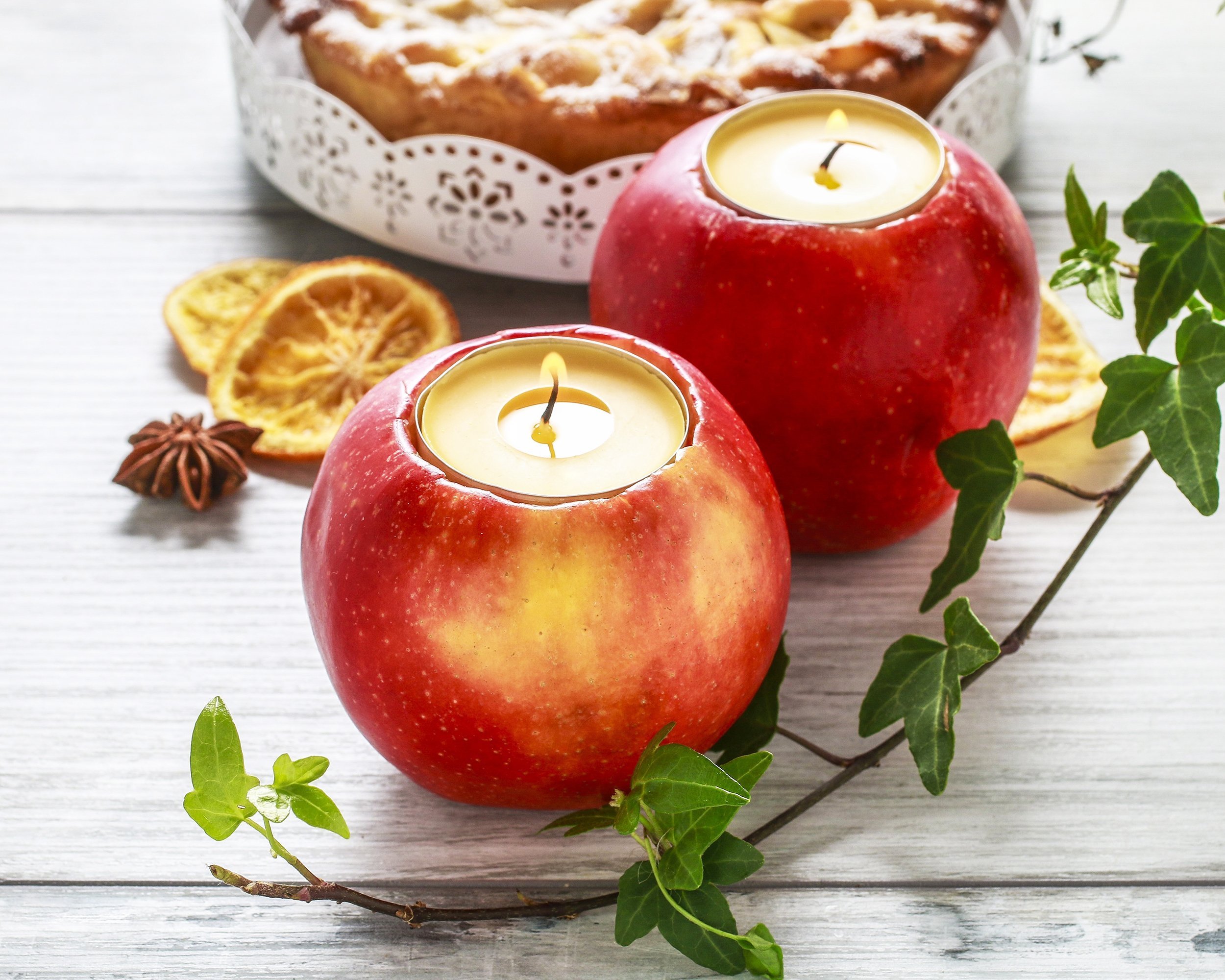 two candles in apple on table