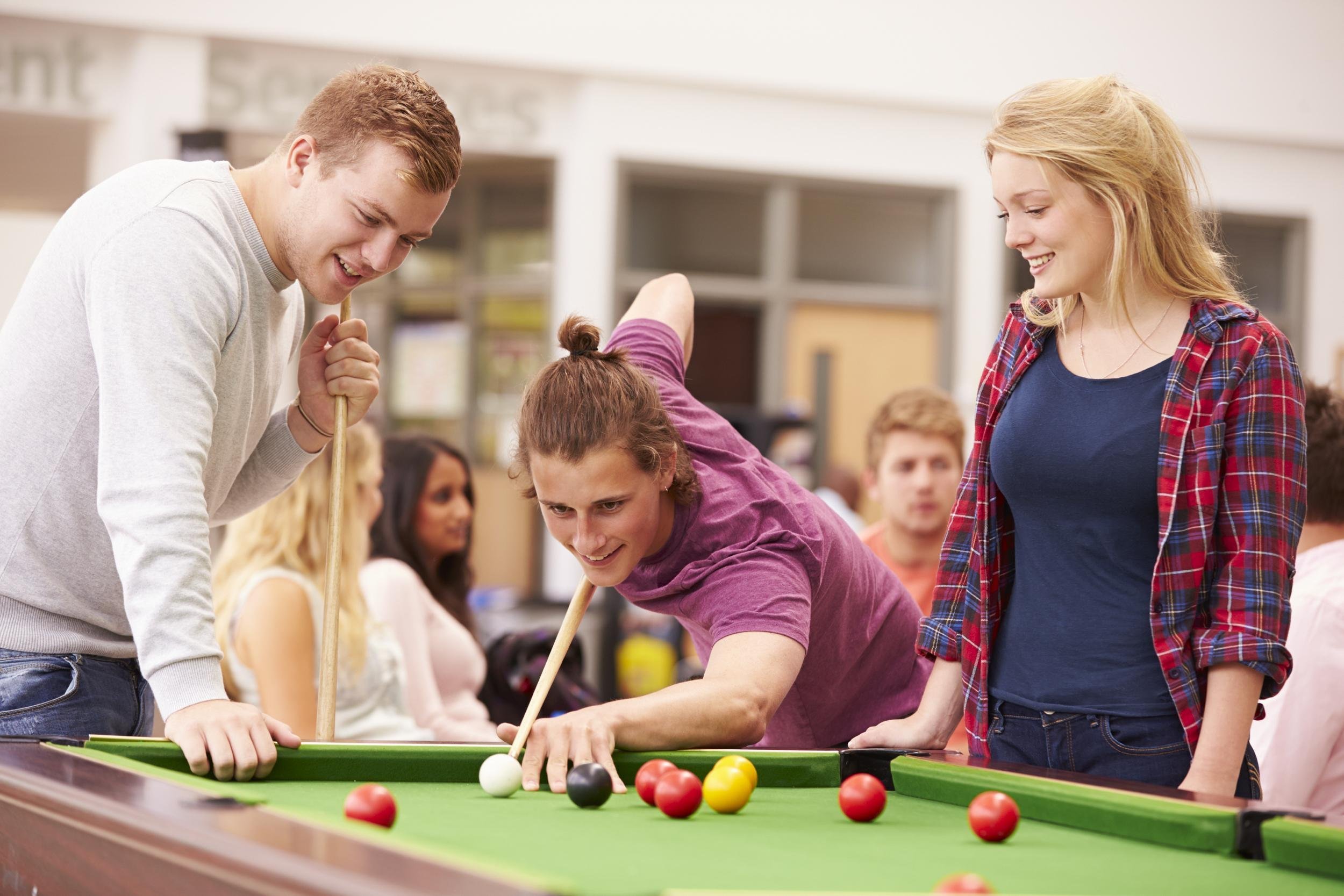 group of college students playing pool